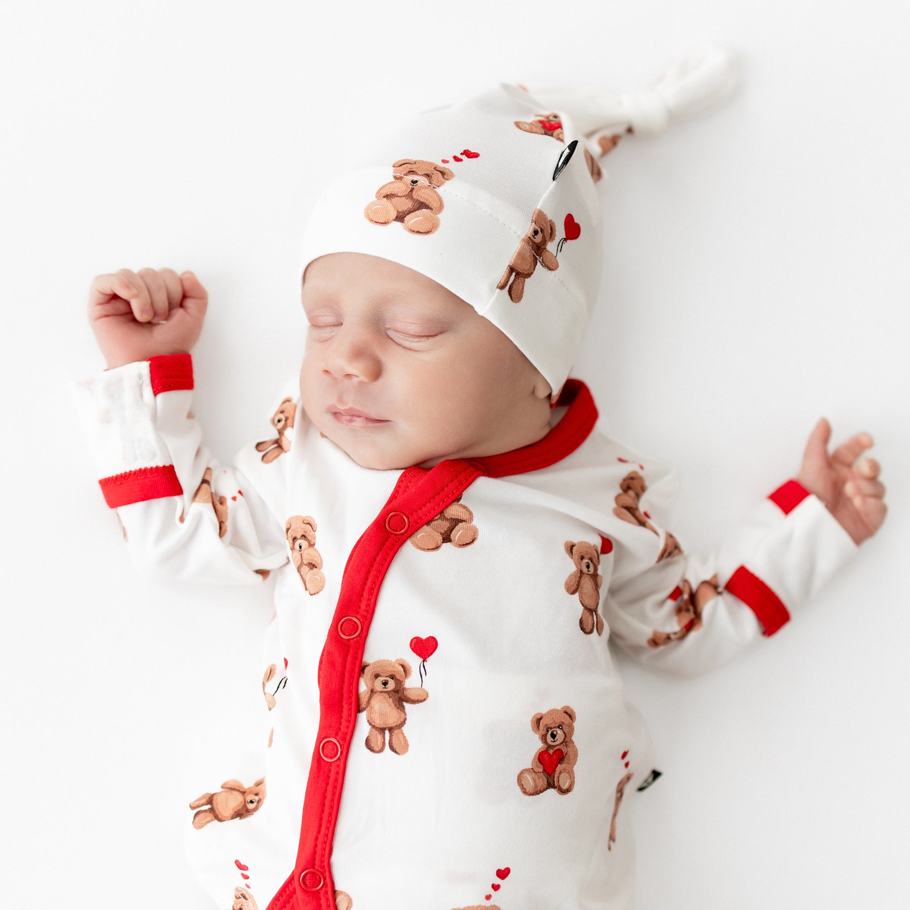 Close up of sleeping newborn wearing the Take Me Home Set with Cap in Bear Hearts