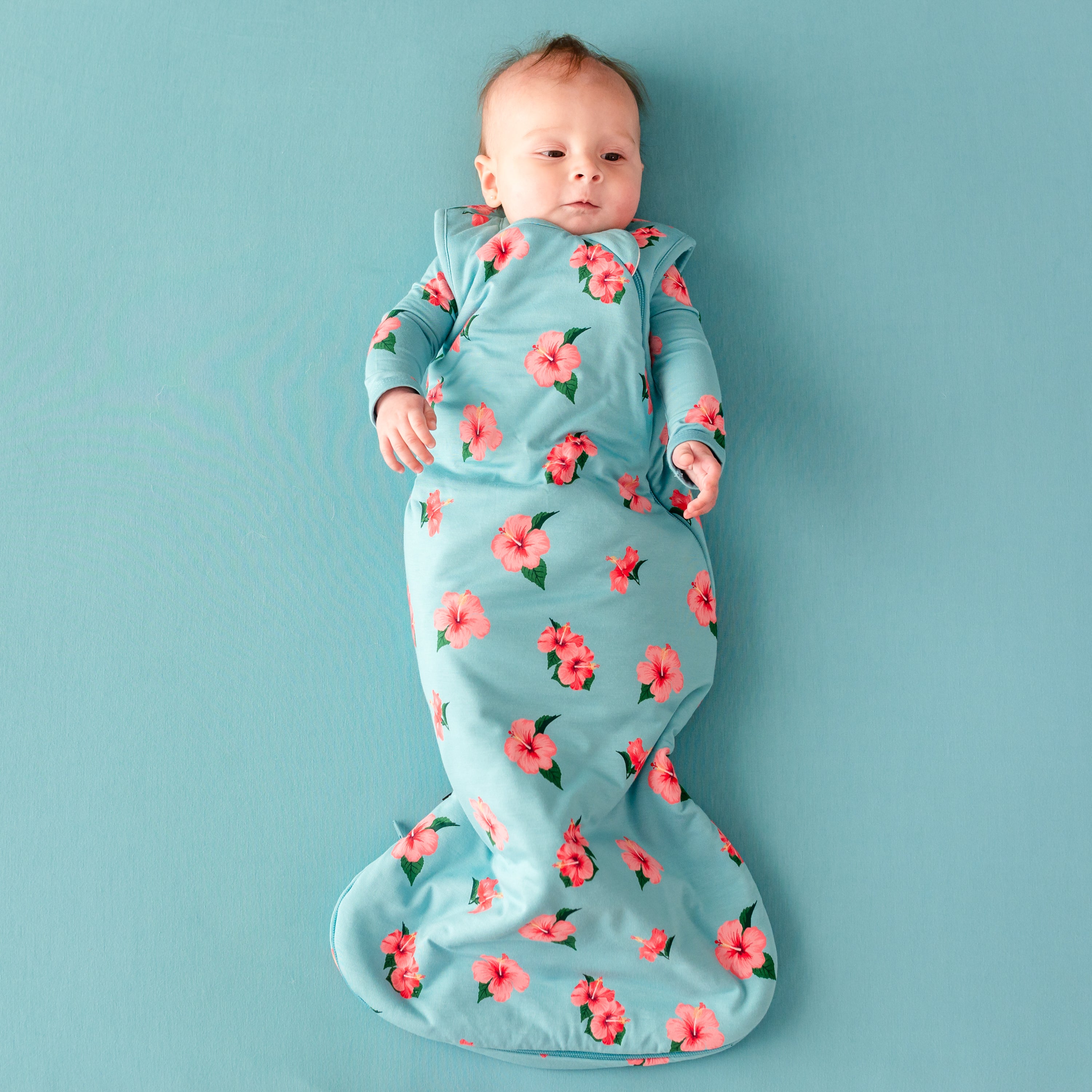 Baby laying in Kyte Baby Sleep Bag in Hibiscus 1.0