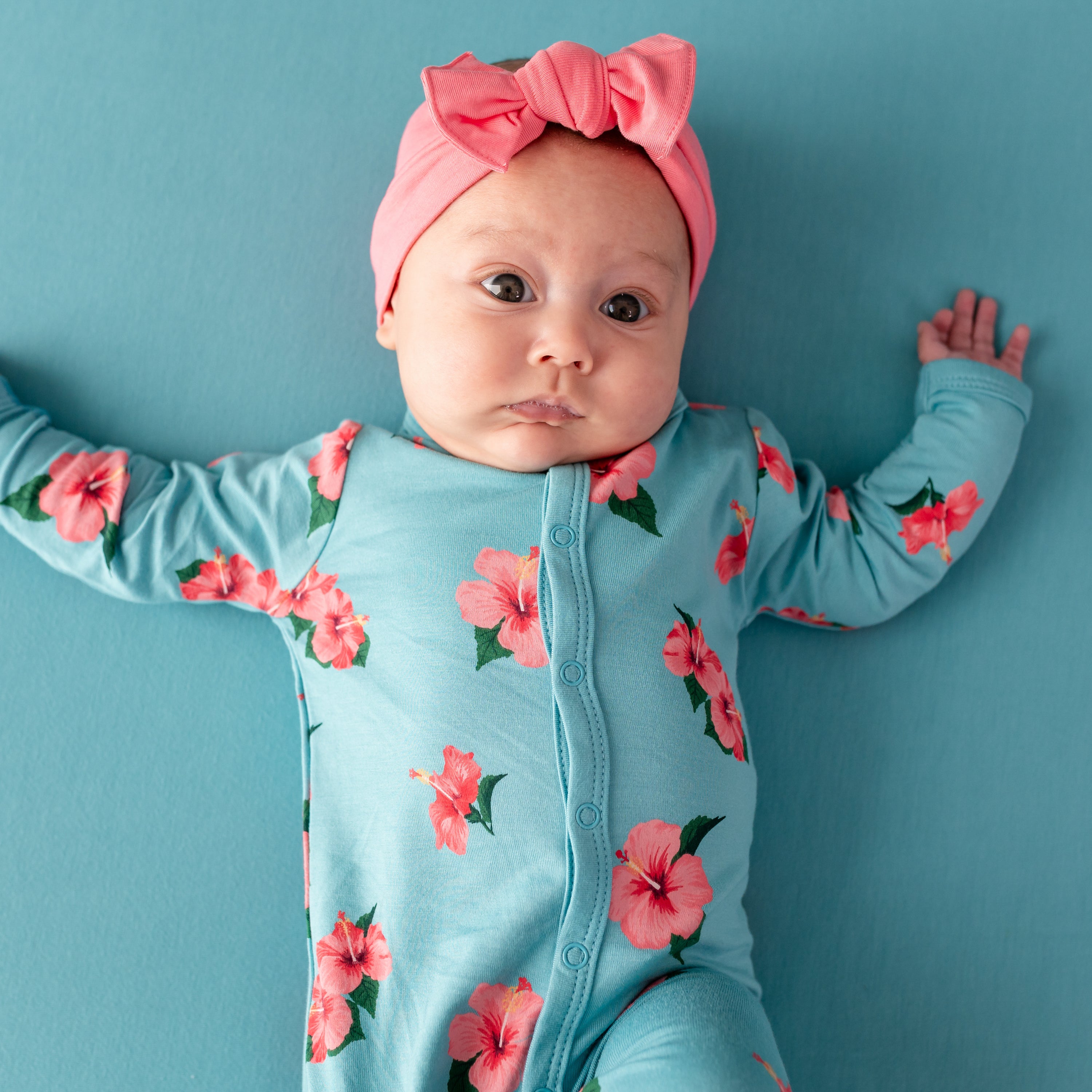 Close up of Baby in Kyte Romper in Hibiscus and Guava Bow