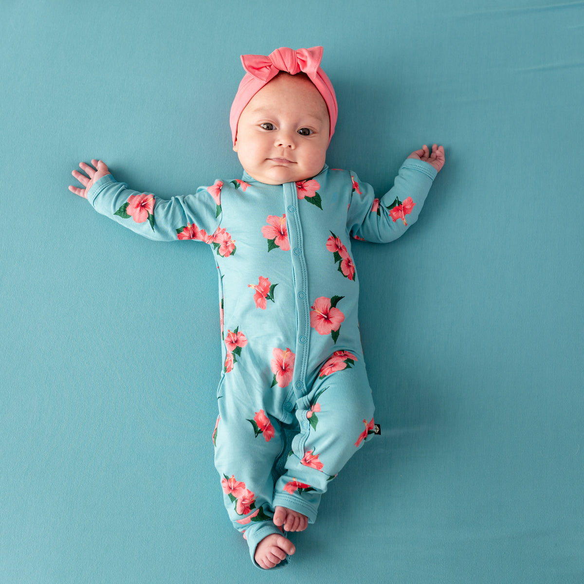 Baby in Kyte Romper in Hibiscus and Guava Bow