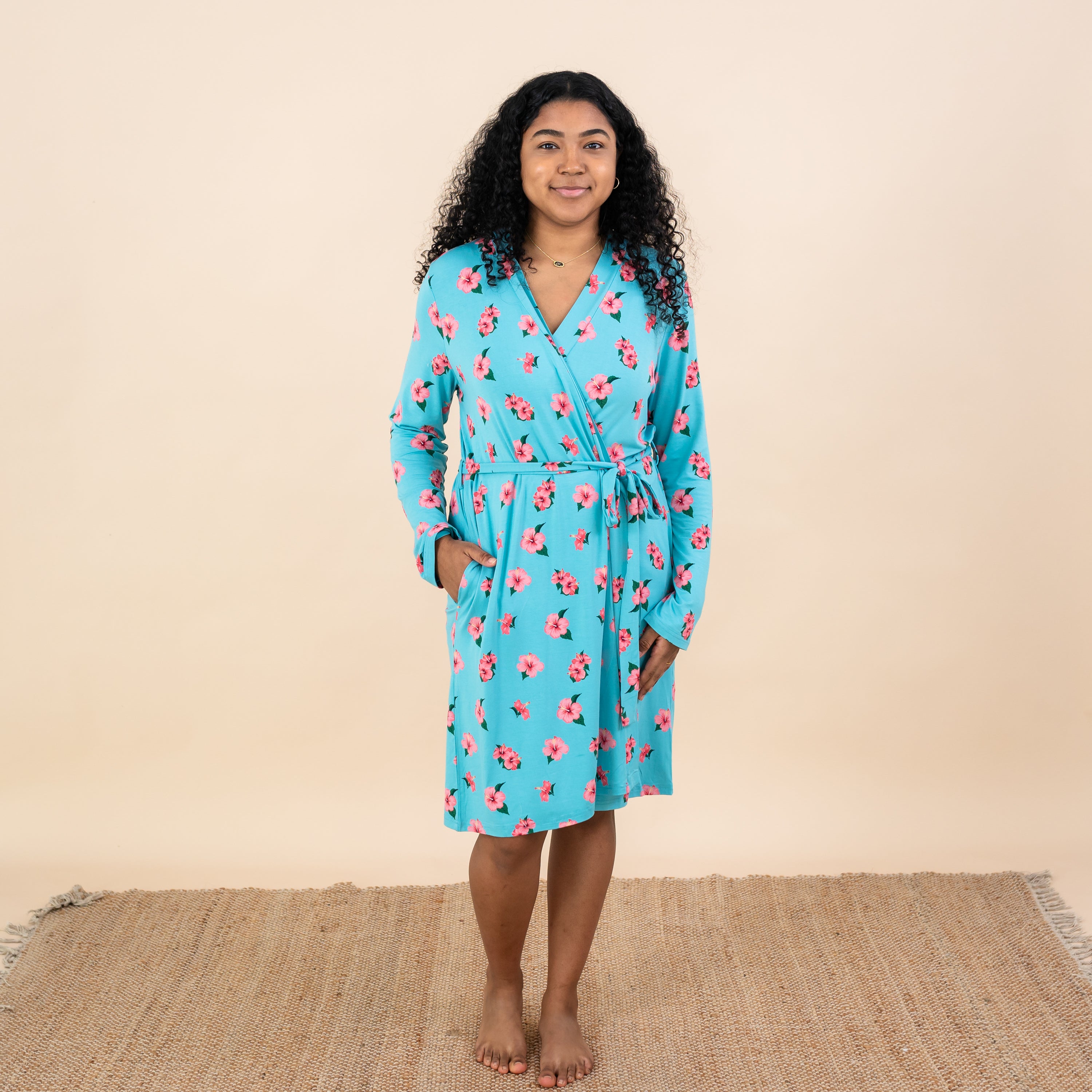 Woman modeling Kyte Women’s Lounge Robe in Hibiscus showing pockets