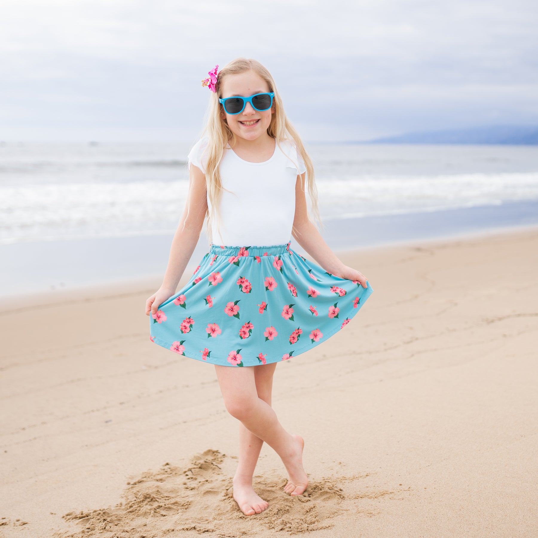 Child modeling Kyte Skort in Hibiscus on the beach