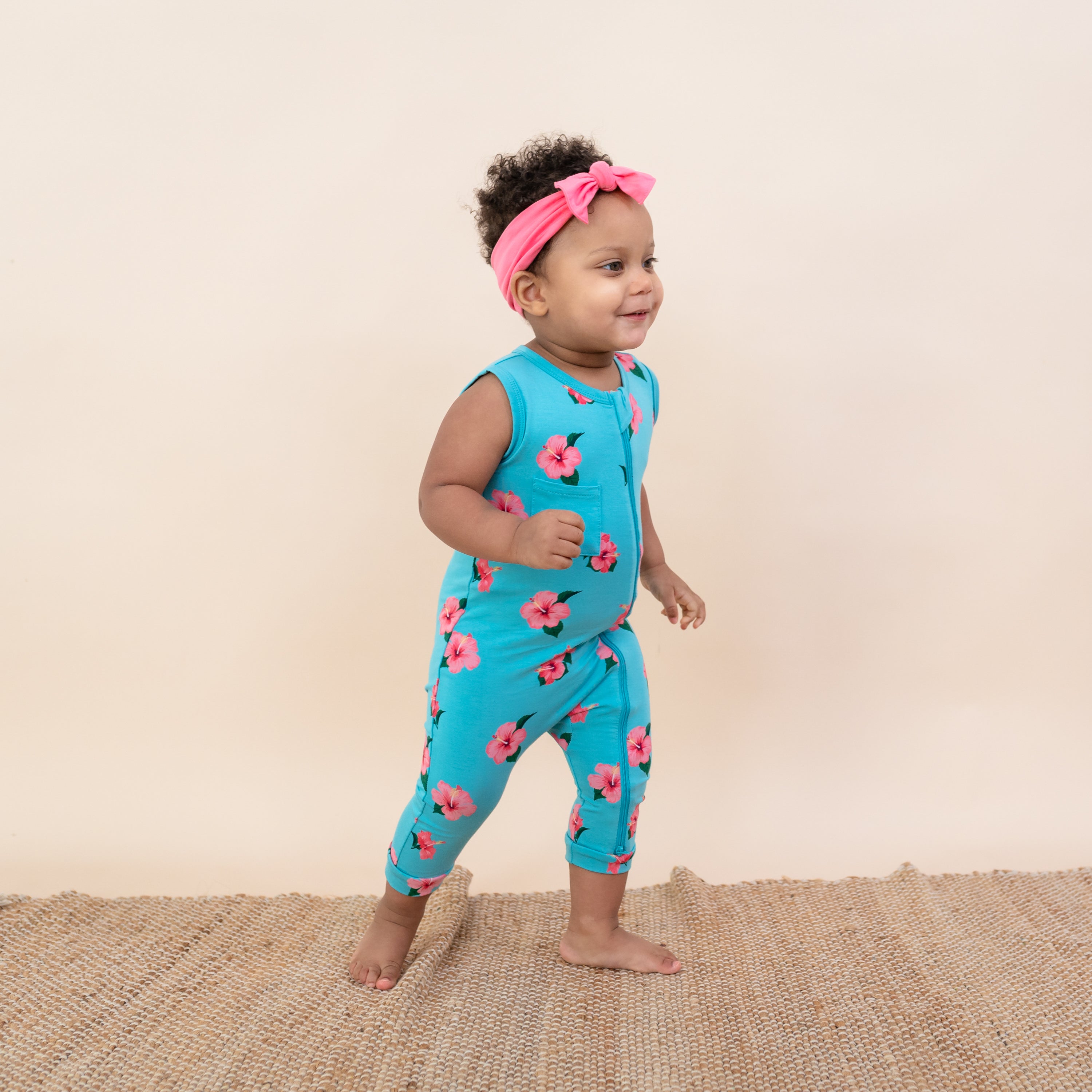 Toddler in Kyte Zippered Sleeveless Romper in Hibiscus and Guava Bow