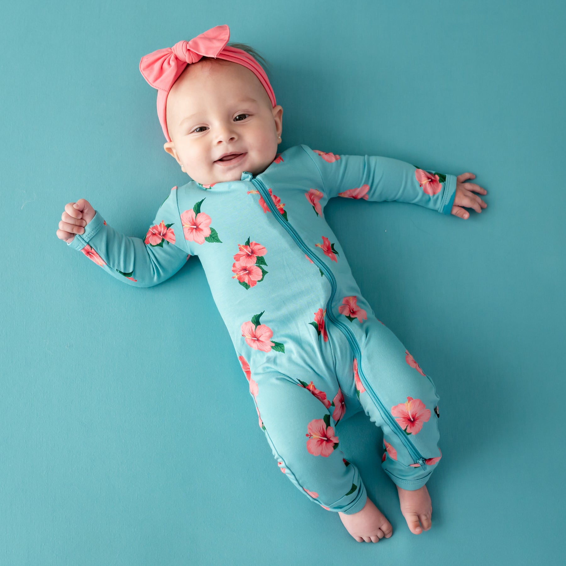 Baby modeling Kyte Baby Zippered Romper in Hibiscus