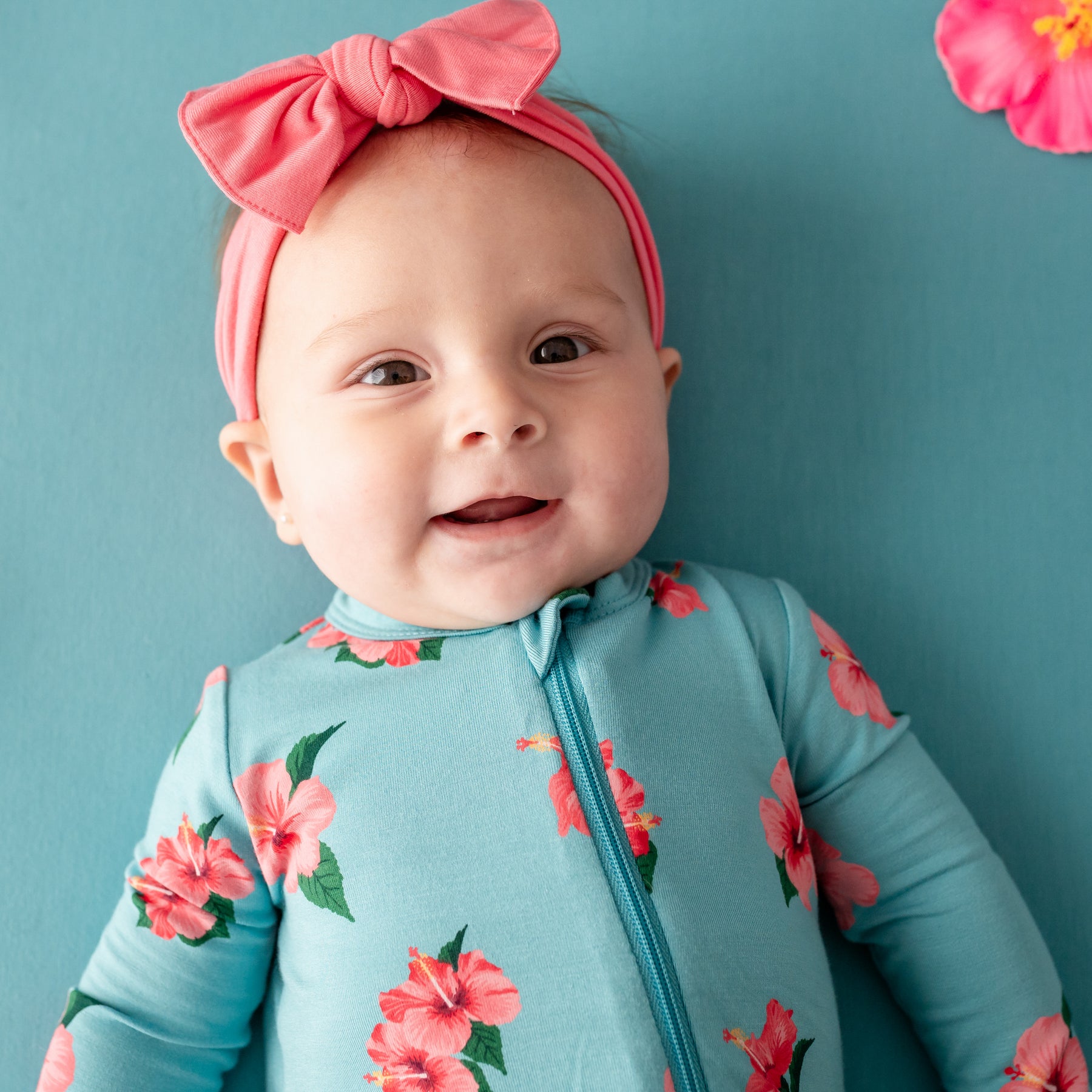 Close up of baby wearing Zippered Romper in Hibiscus