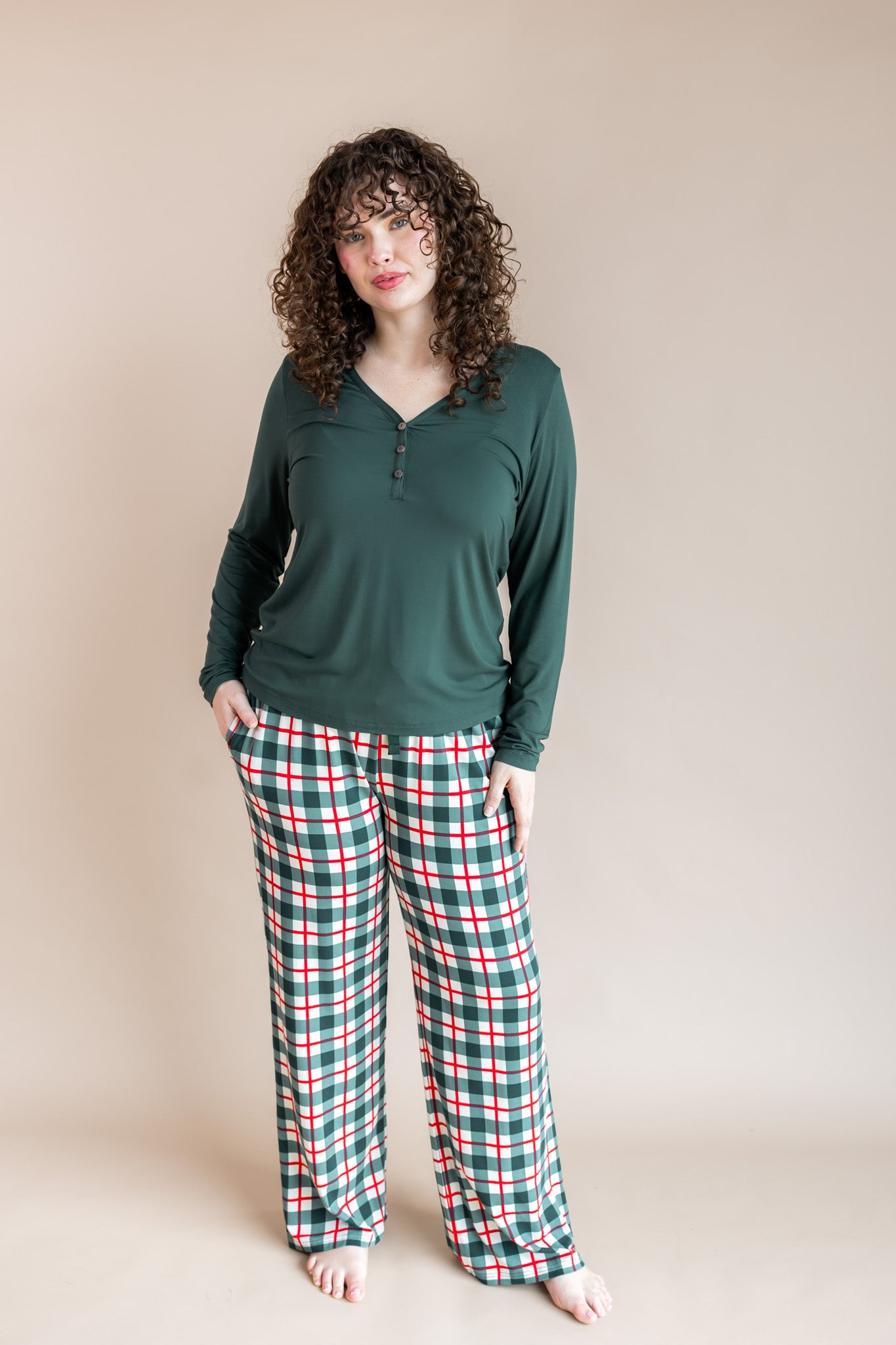 Woman wearing Women's lounge pant in holiday plaid print over cypress color T-shirt on a beige background
