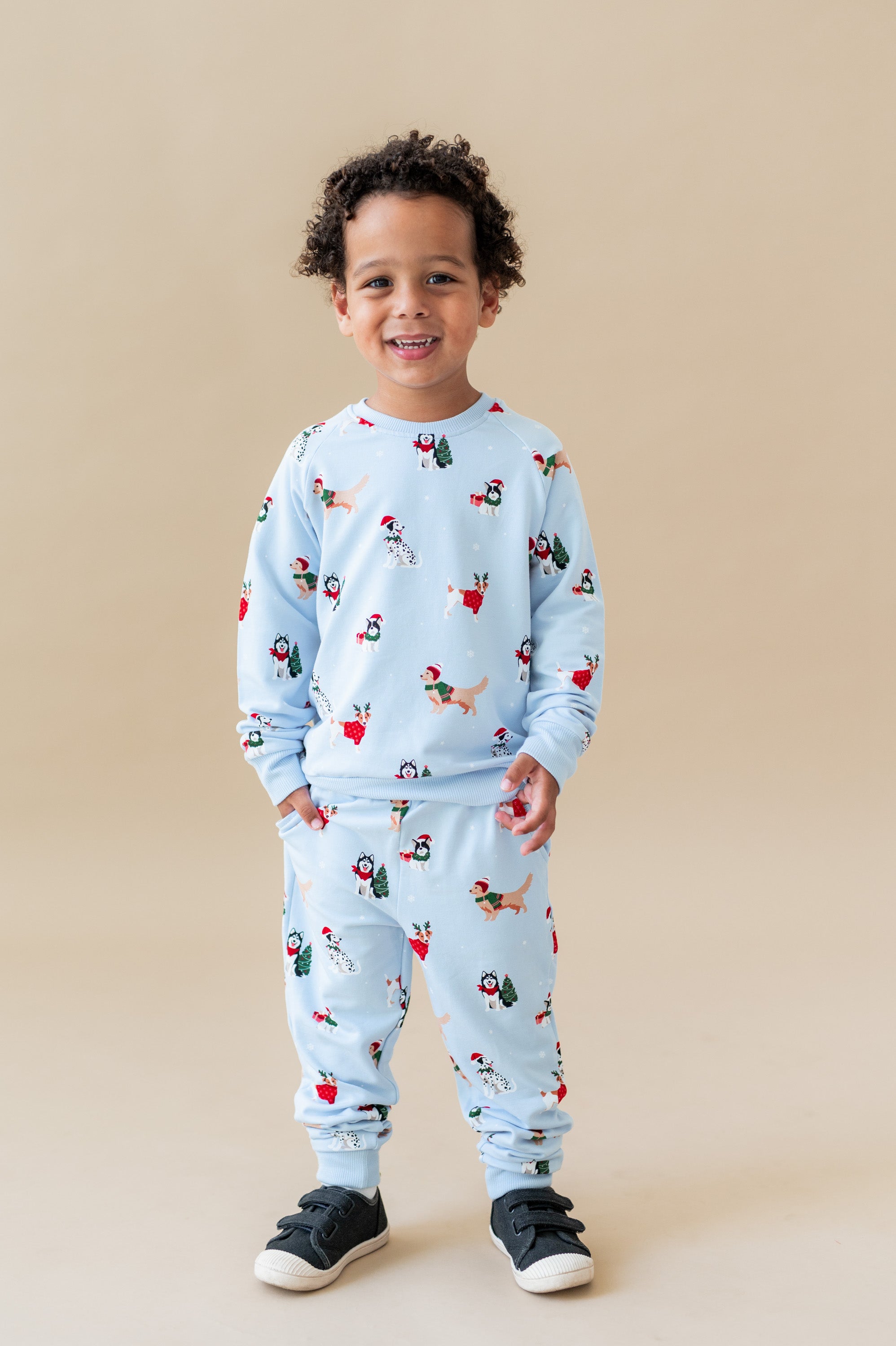 Boy wearing Long Sleeve Jogger Set in Holiday Pups print on a beige background