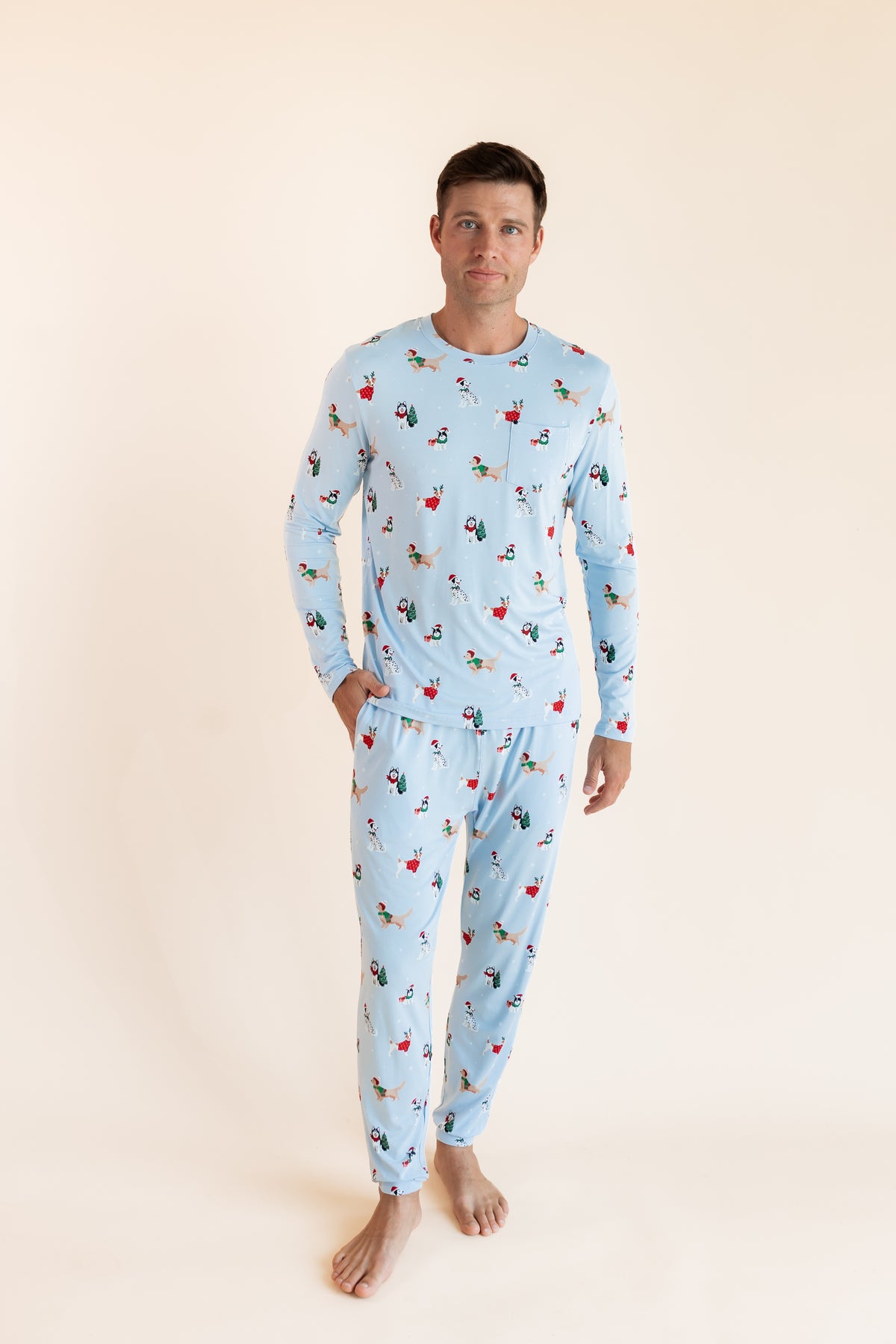 Man wearing Men's Jogger Set in Holiday Pups print on a beige background