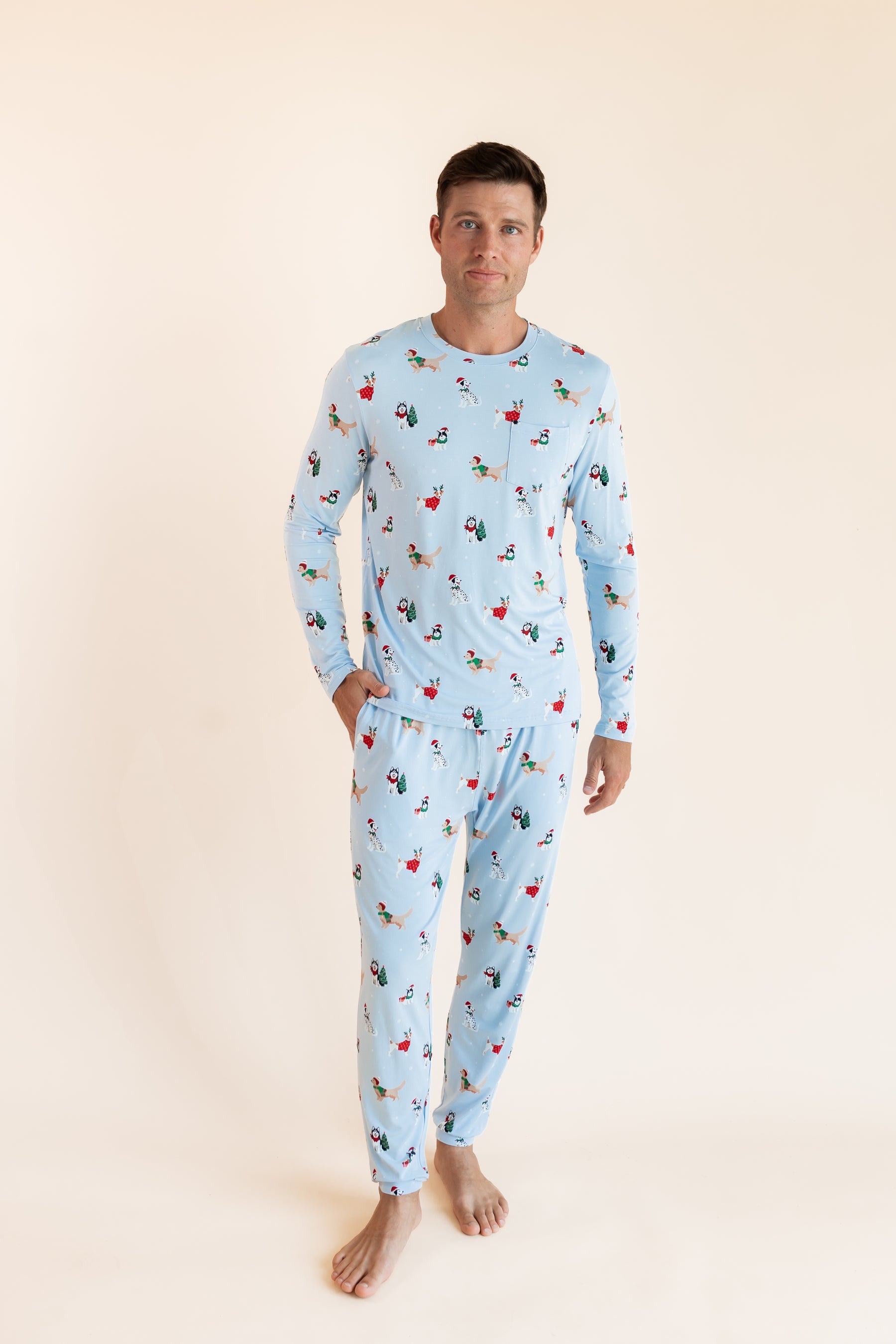 Man wearing Men's Jogger Set in Holiday Pups print on a beige background