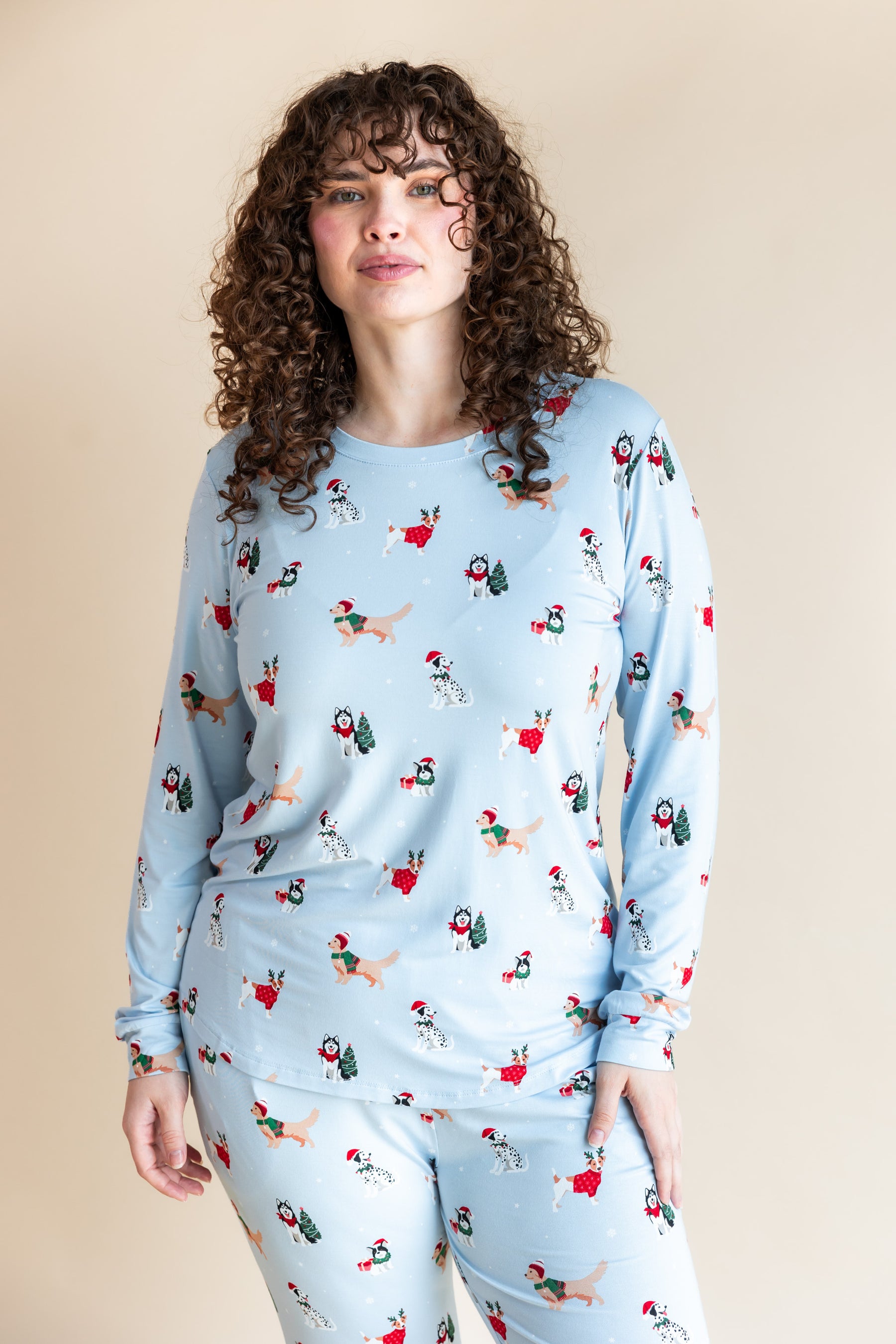 Woman wearing Women's Jogger Pajama Set in Holiday Pups print on a beige background
