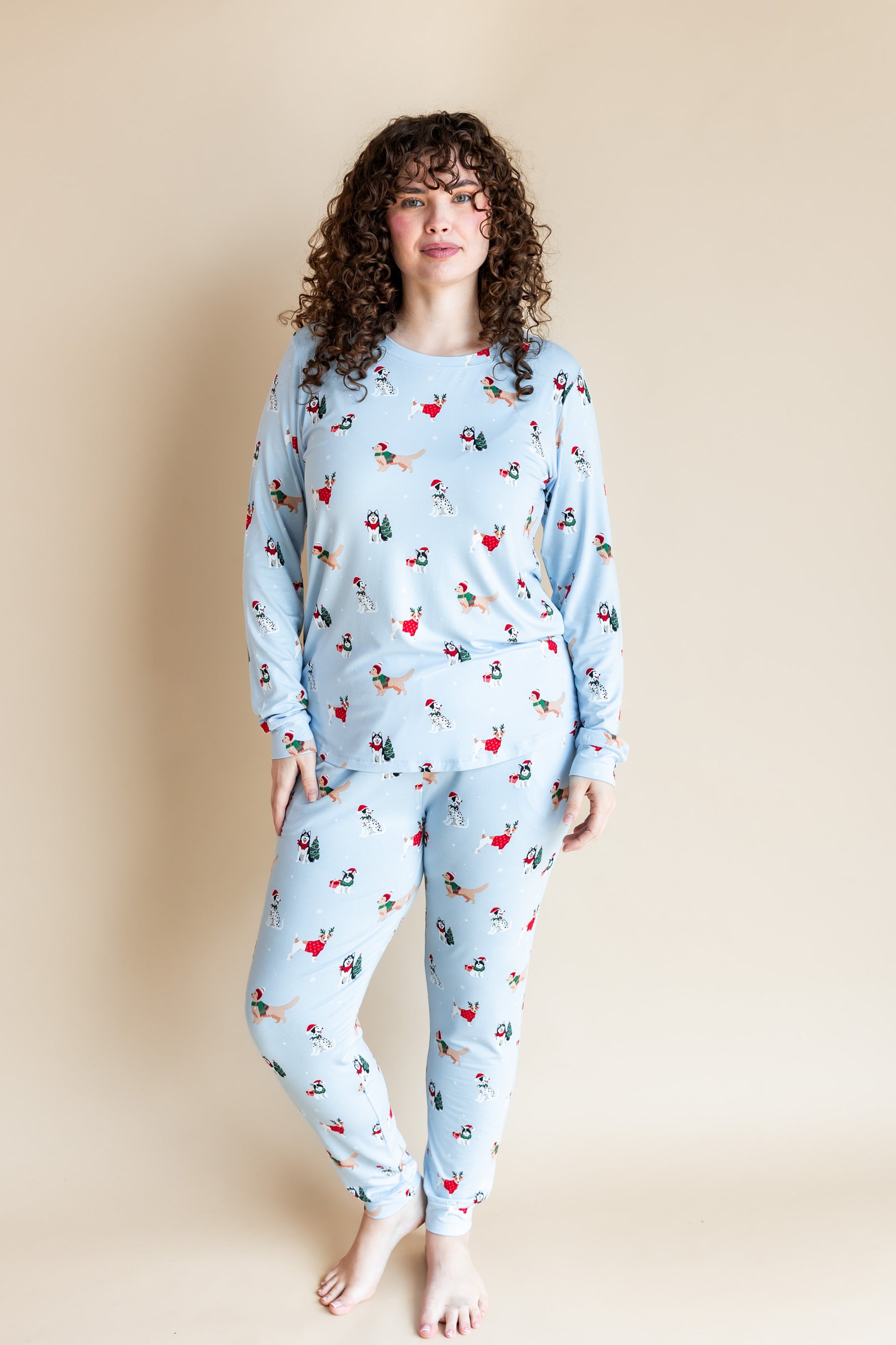 Woman posing in Women's Jogger Pajama Set in Holiday Pups print on a beiege background