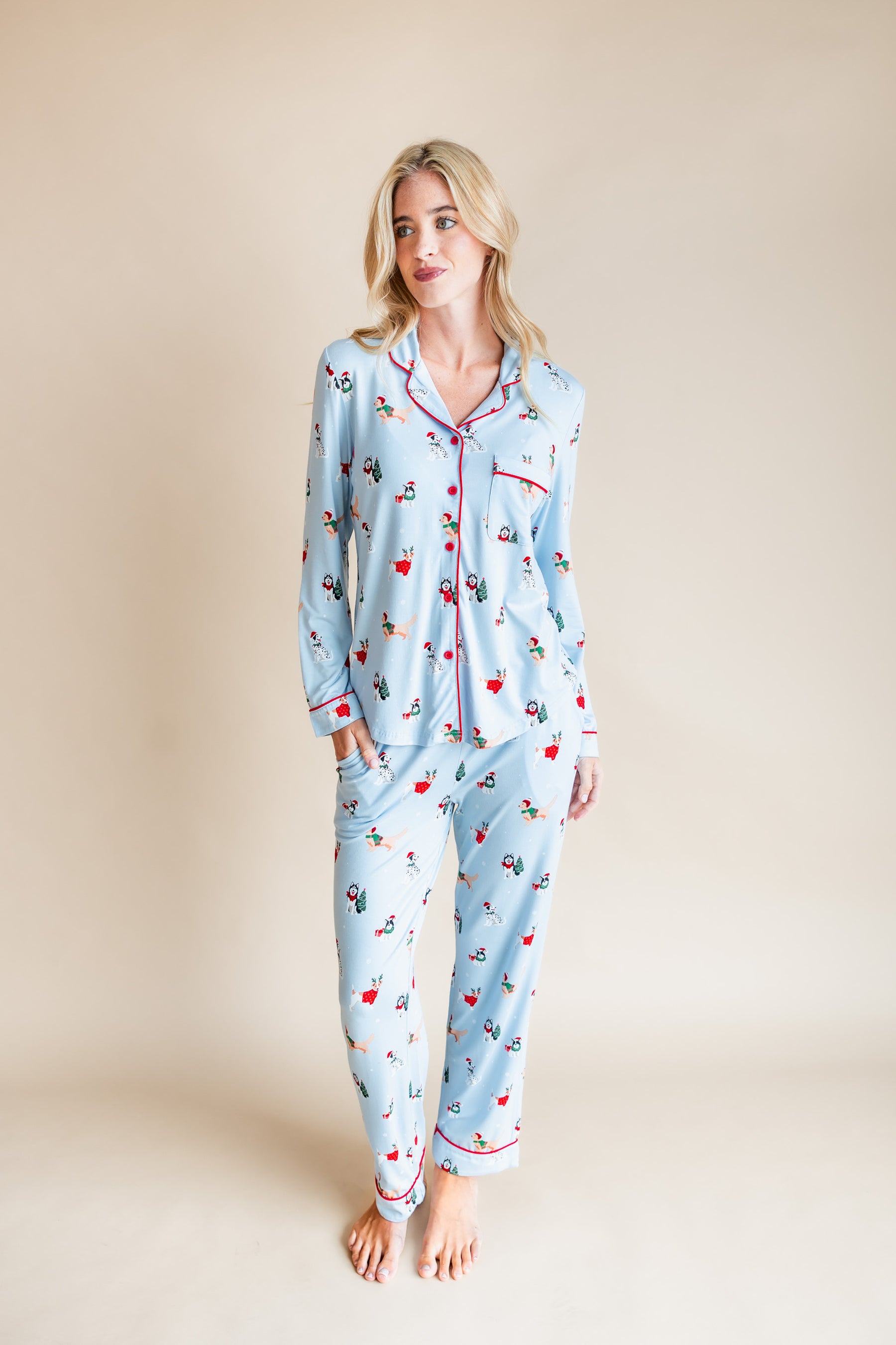 Woman wearing Long-Sleeved Women's Pajama Set in Holiday Pups print on a beige background