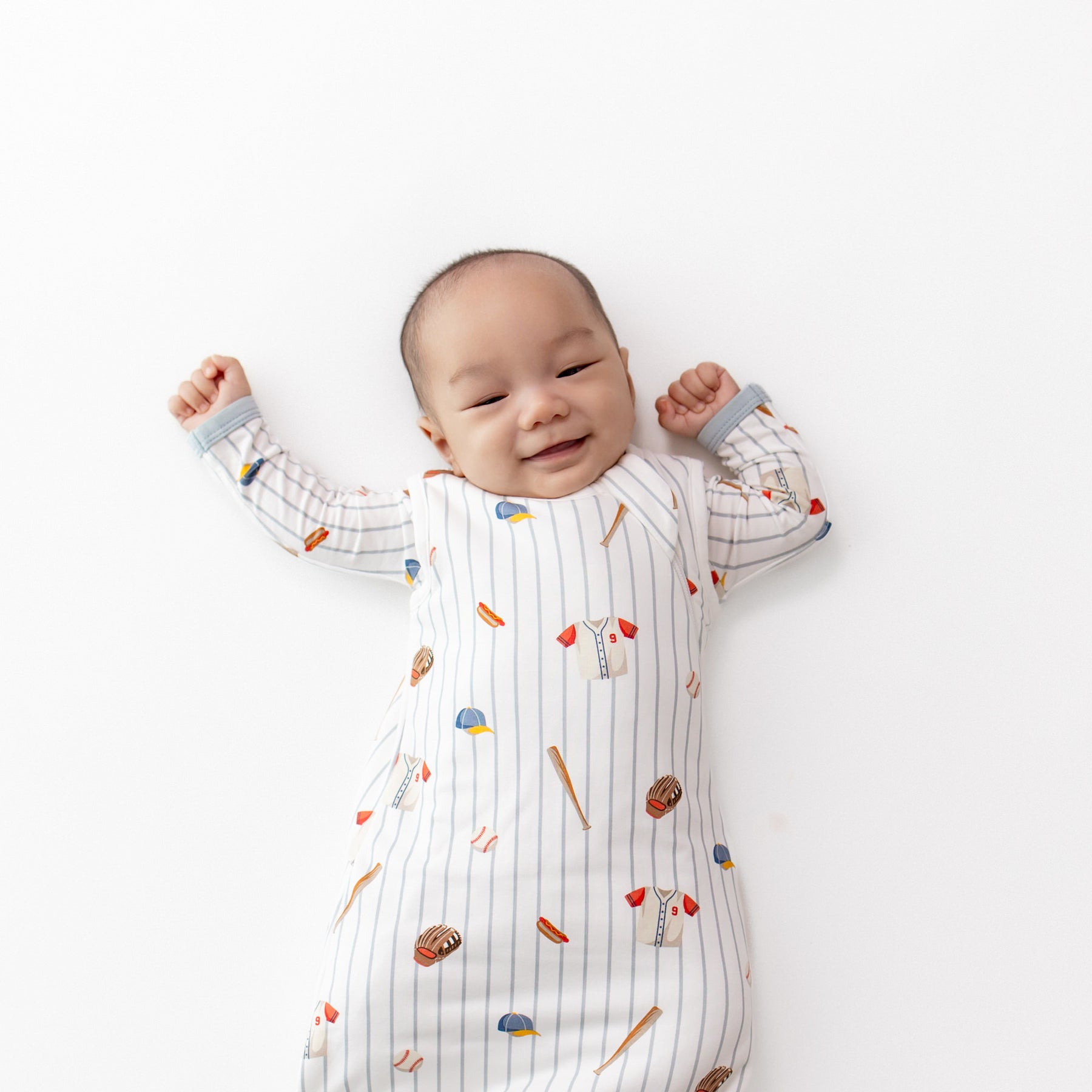 Close up of an infant wearing the Sleep Bag in Home Run 1.0 with a matching romper
