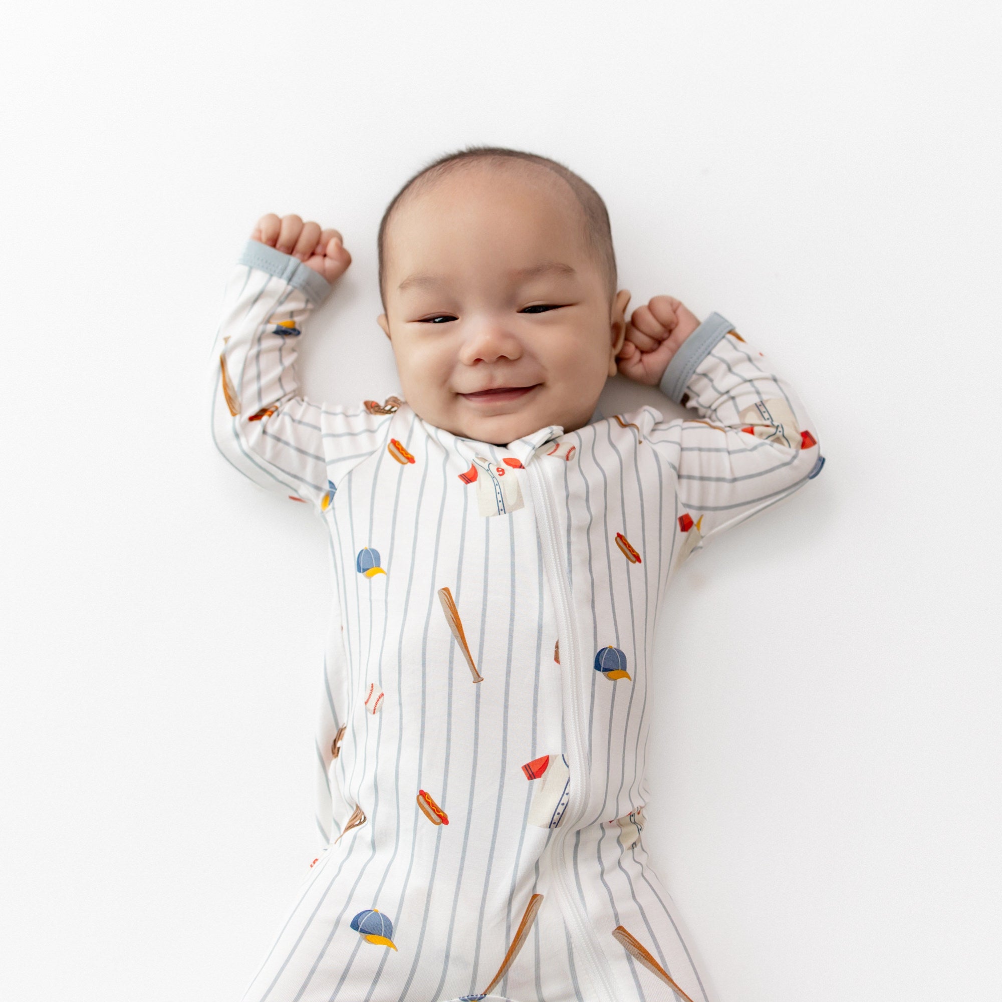 Close up of infant stretching wearing the Zippered Footie in Home Run