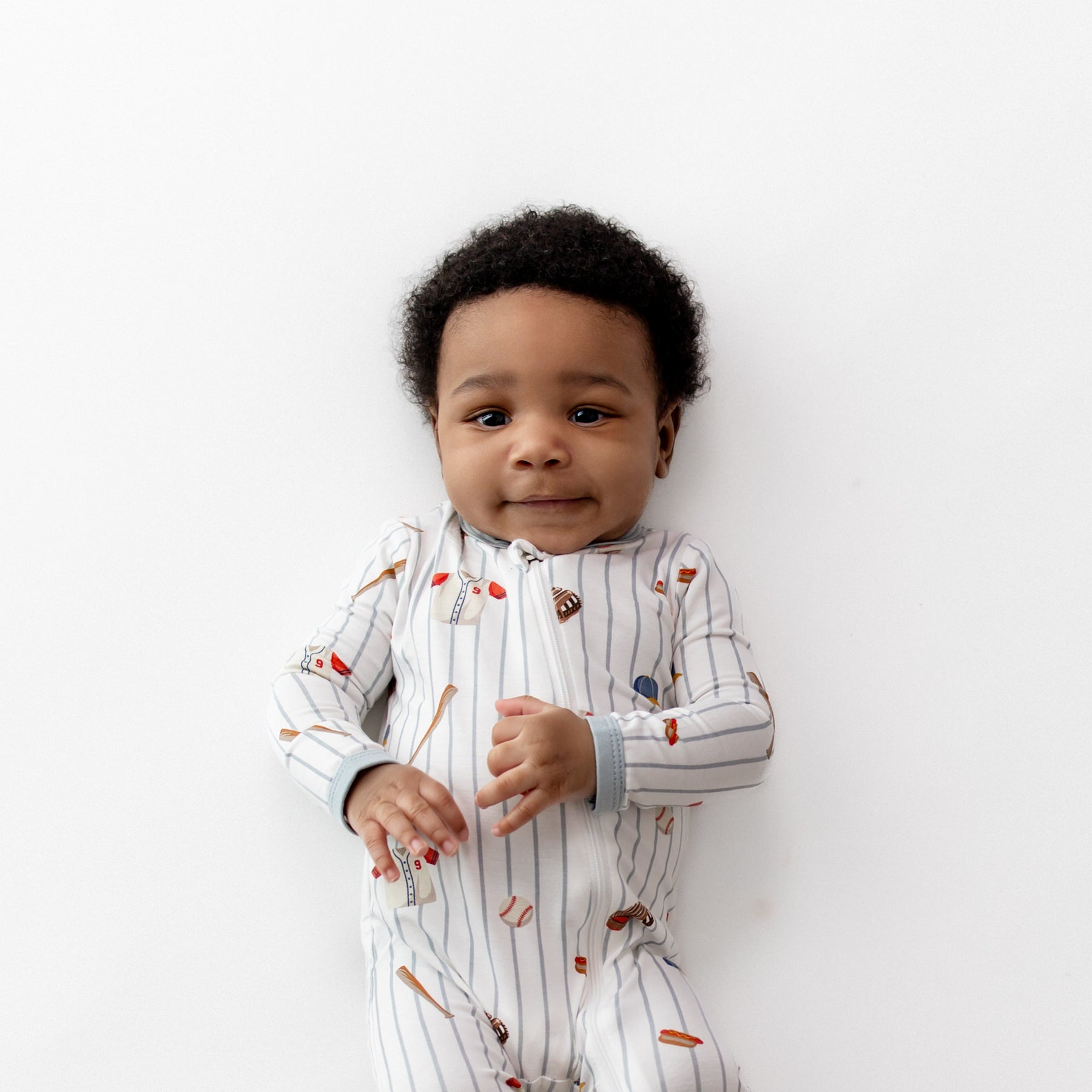 Close up of the Zippered Romper in Home Run shown on an infant