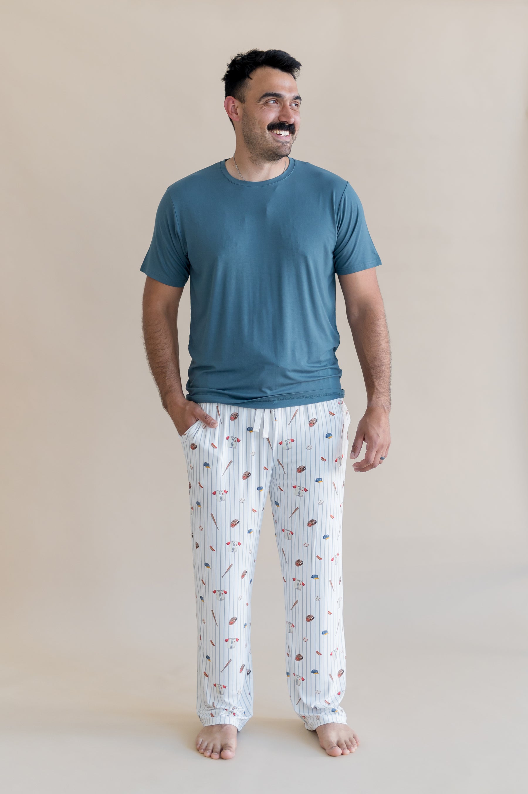 Male model wearing the Men's Lounge Pants in Home Run with a muted dark blue shirt