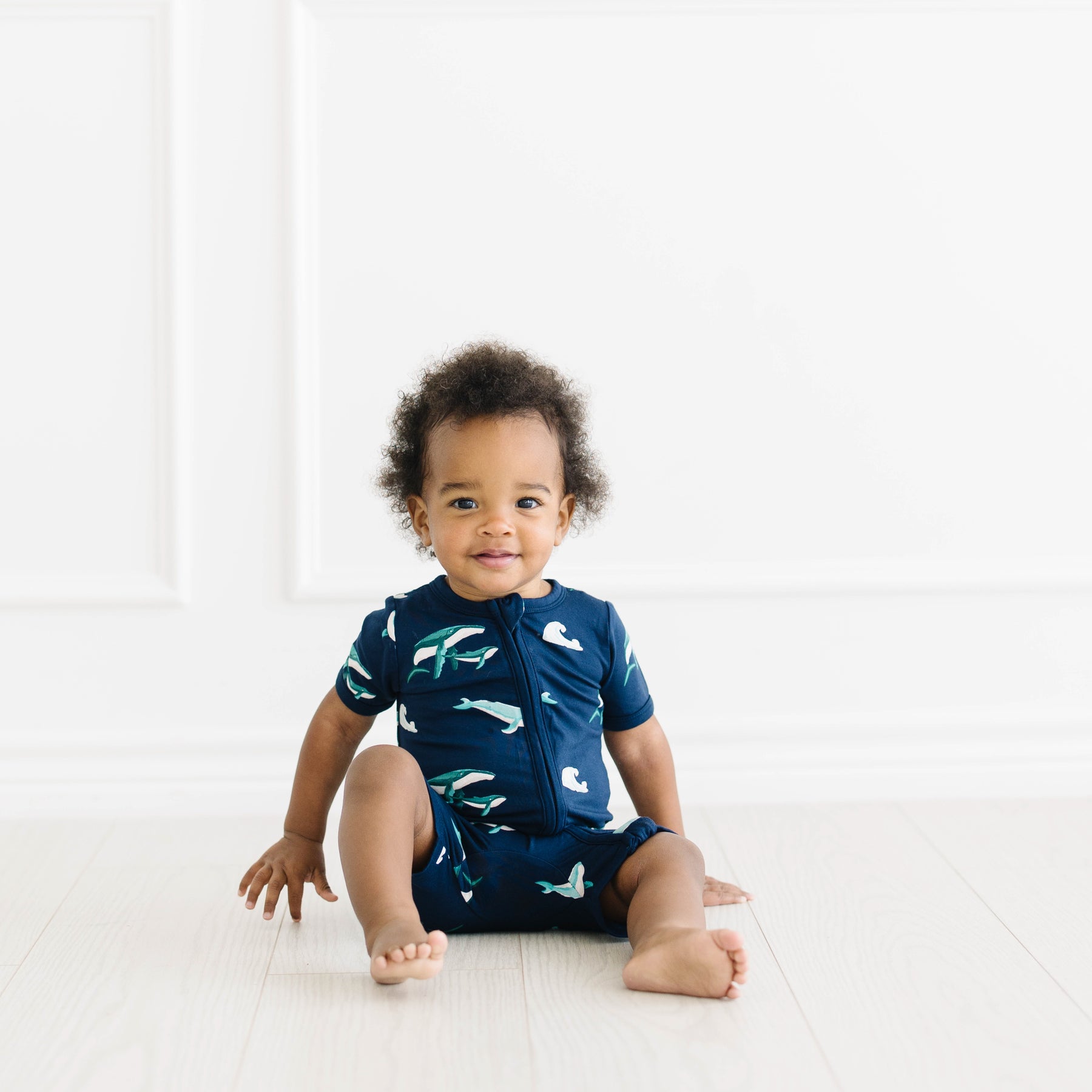 toddler sitting and modeling zippered shortall romper in humpback