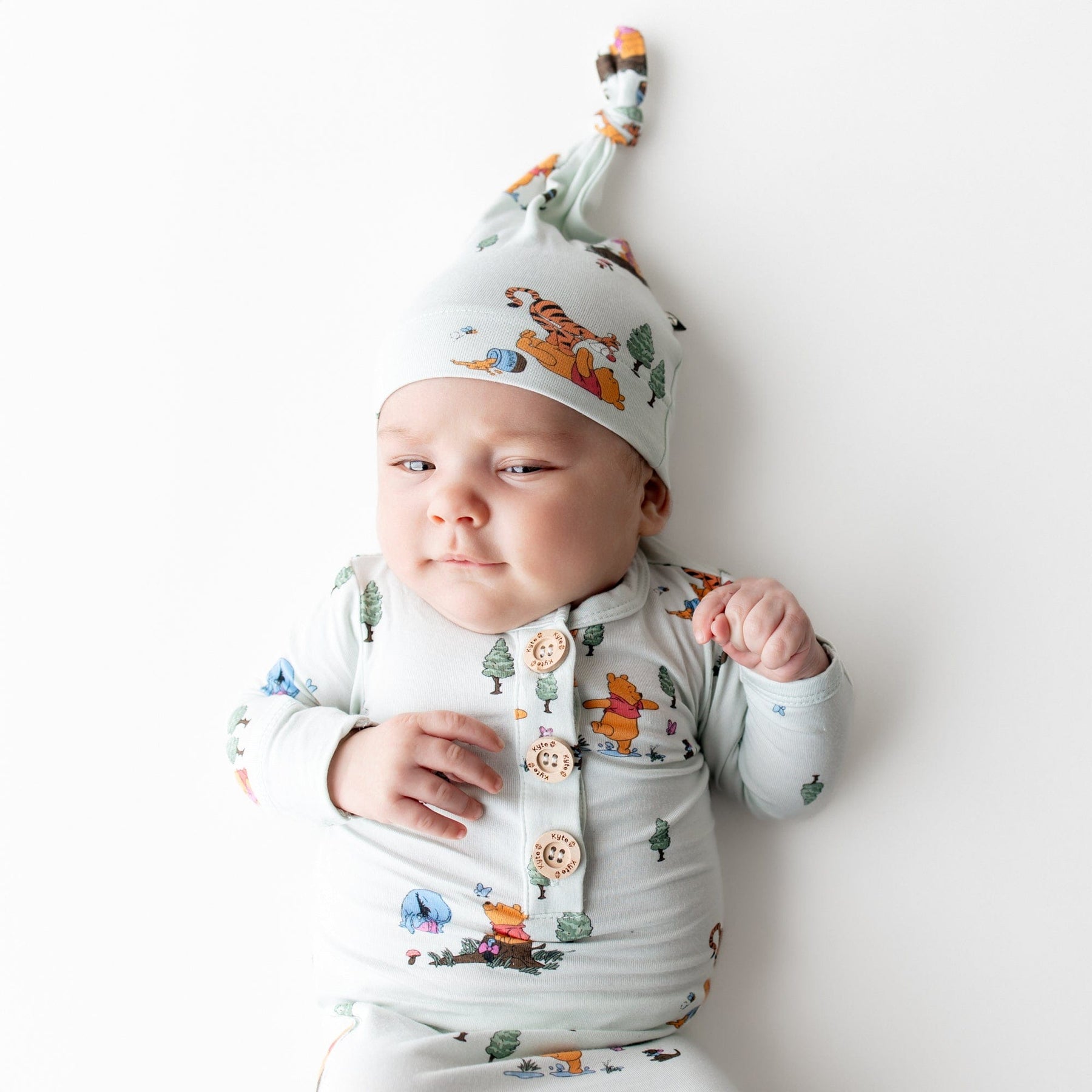 Close up of infant wearing the Knotted Gown with Hat Set in Winnie the Pooh Hundred Acre Wood