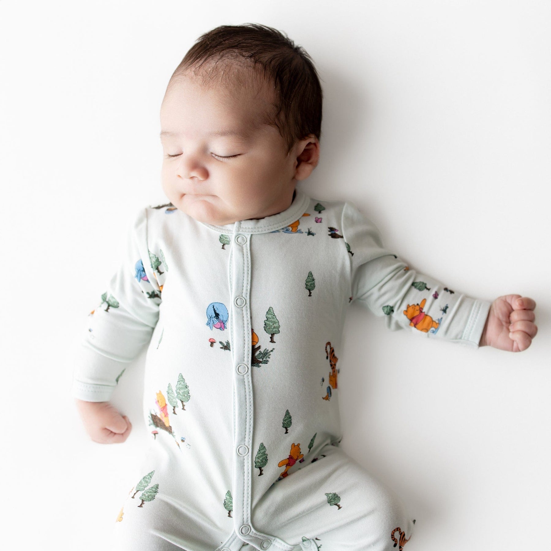 Close up of sleeping newborn wearing the Romper in Winnie the Pooh Hundred Acre Wood