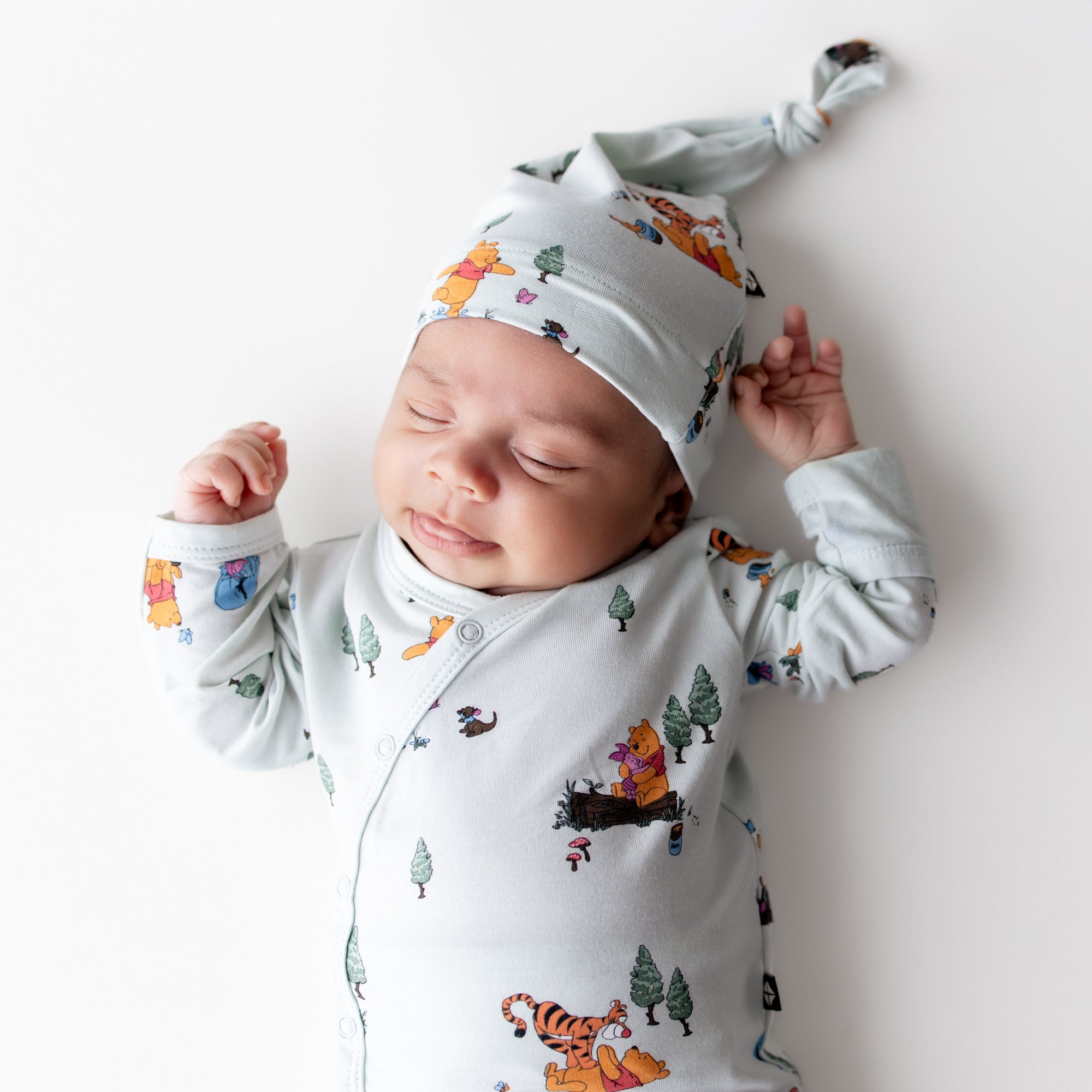Close up of sleeping newborn wearing the Take Me Home Set with Cap in Winnie the Pooh Hundred Acre Wood