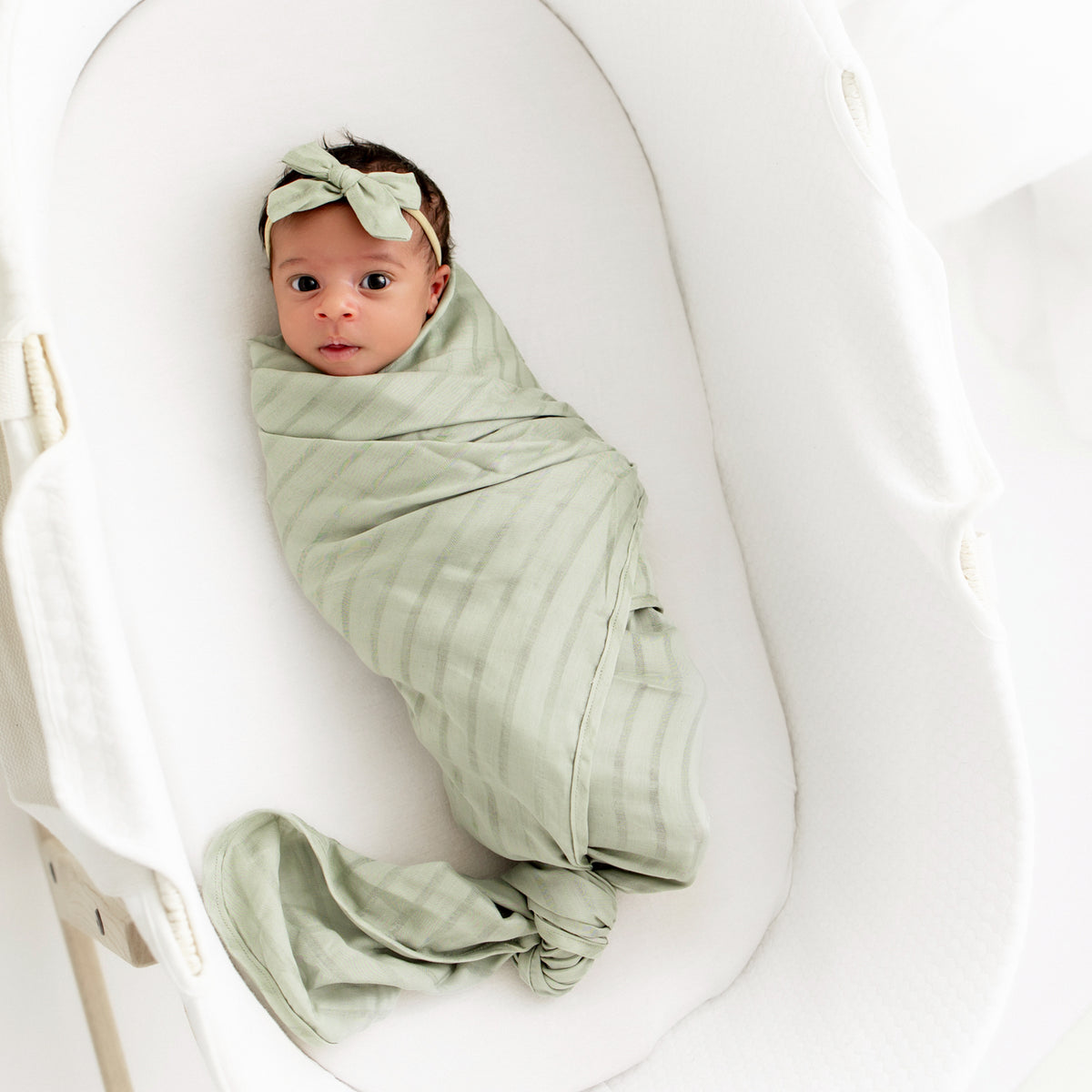 Baby swaddled in Bamboo Muslin Swaddle Blanket in Jojoba Green