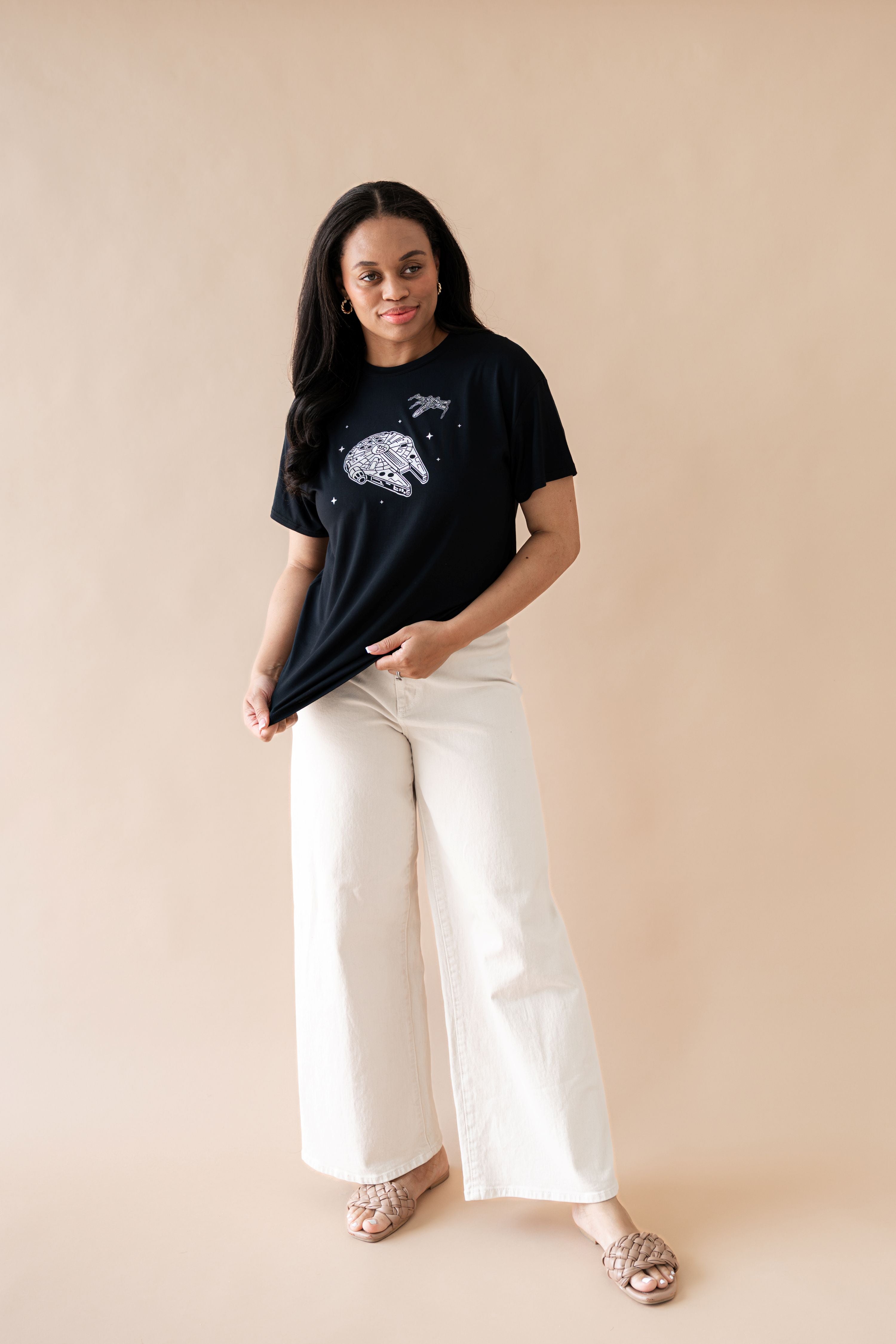 Female modeling the Women's Graphic Tee in Millennium Falcon™ paired with wide leg cream pants