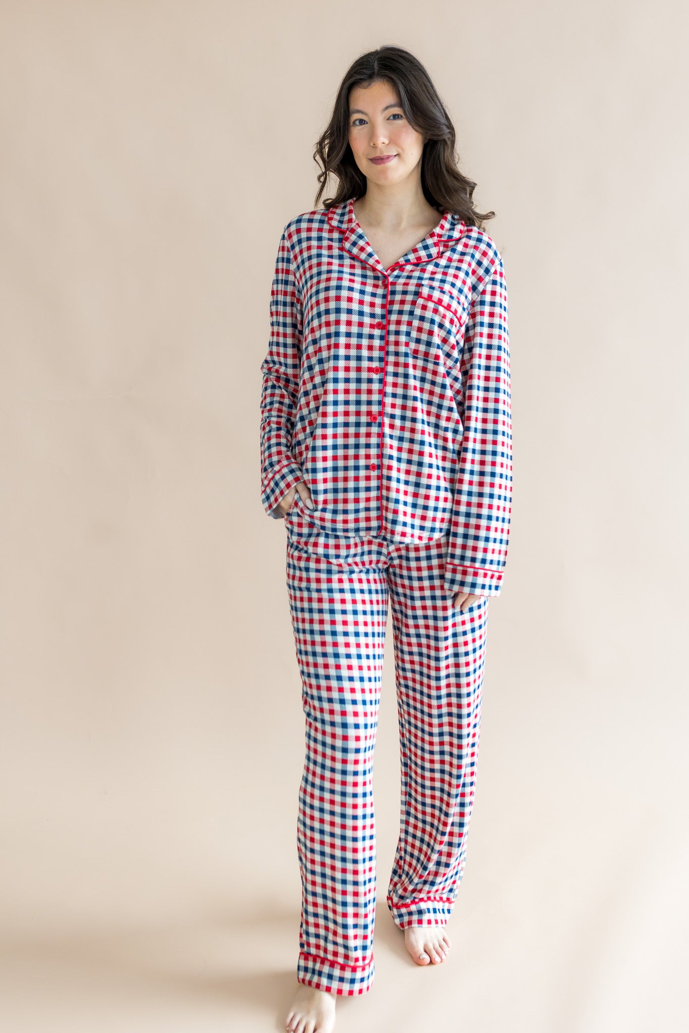 Model wearing Long-Sleeved Women's Pajama Set in red blue and white Patriotic Gingham check print on a beige background