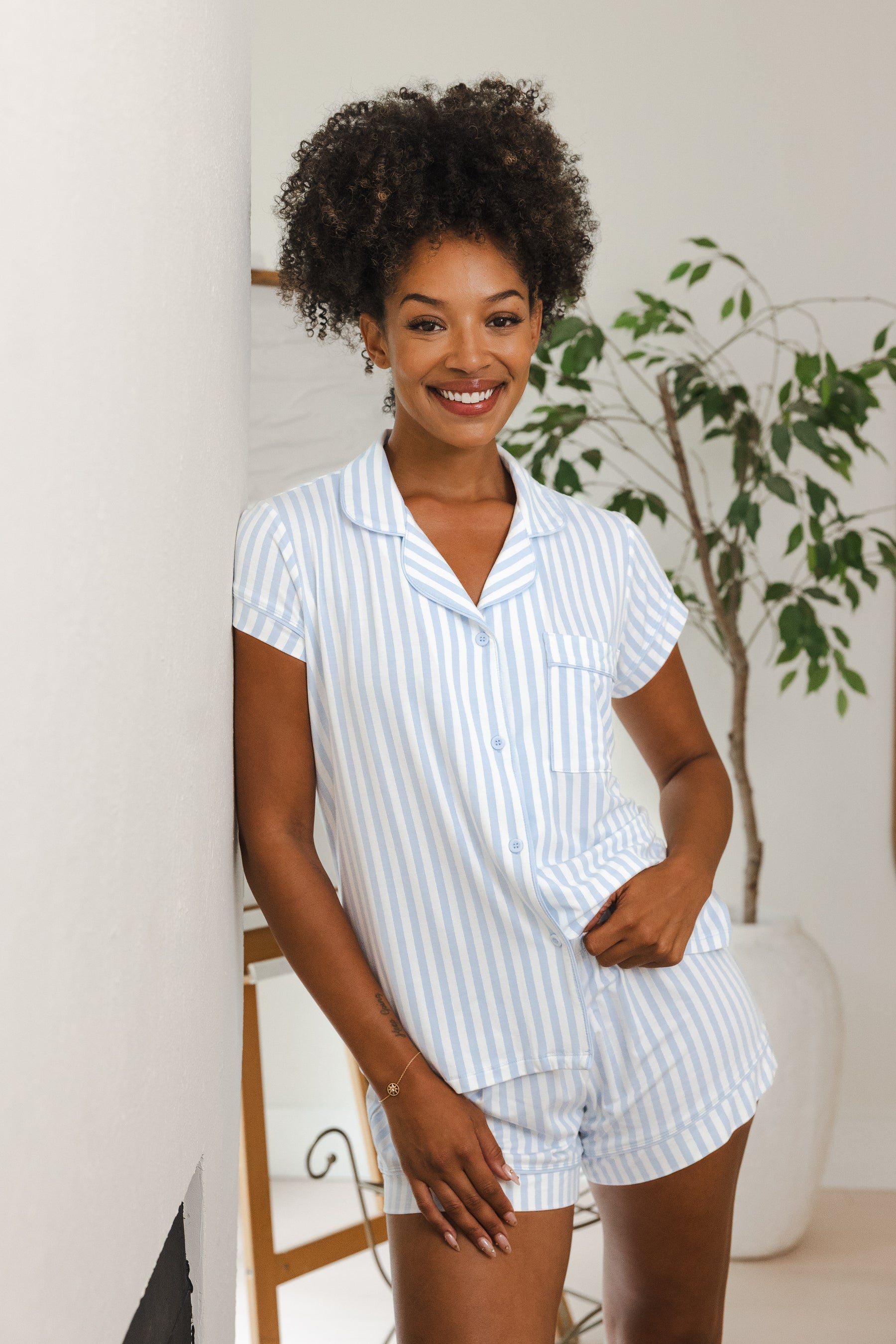 Female model leaning against a wall wearing the Women's Short Sleeve Pajama Set in Small Mist Stripe