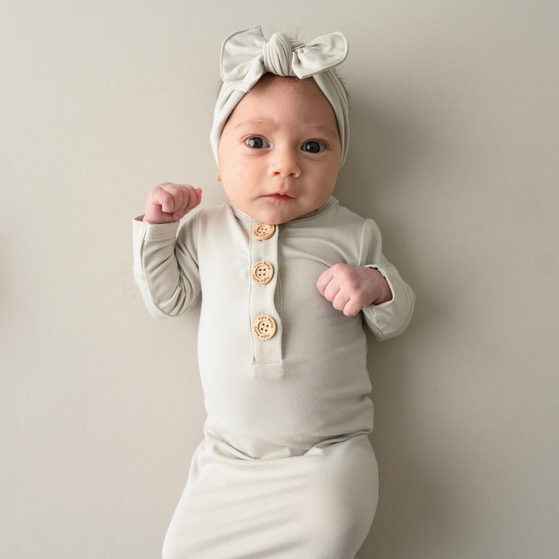 Baby wearing Knotted Gown with Bow Set in Oat close up