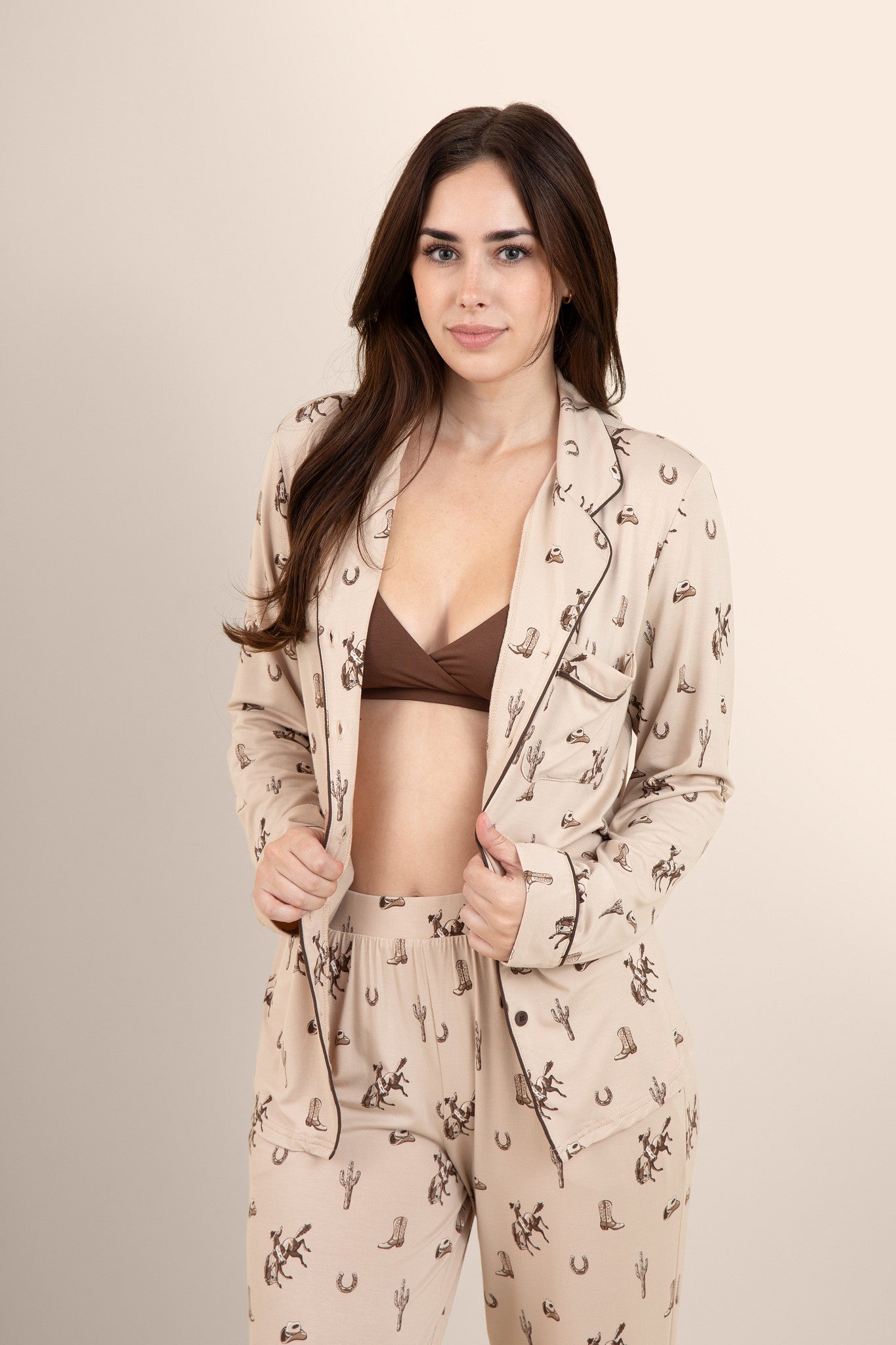 Female modeling the Long-Sleeved Women's Pajama Set in Classic Cowboy with the shirt unbuttoned showing the espresso cross front bralette on underneath