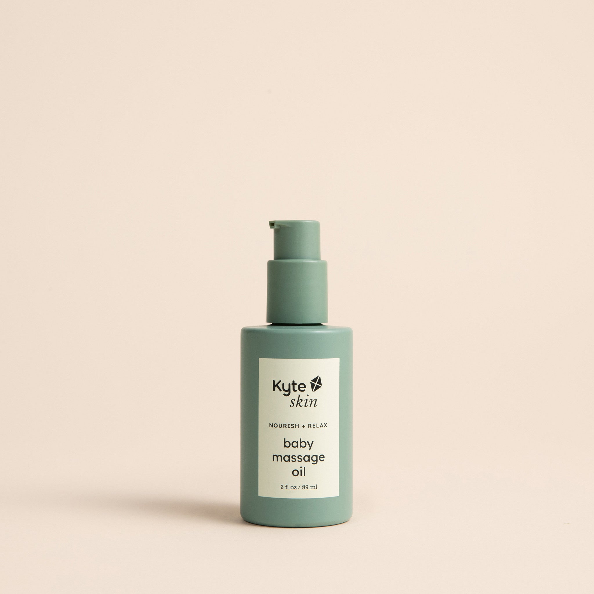 Bottle of Kyte Skin baby massage oil on a beige background