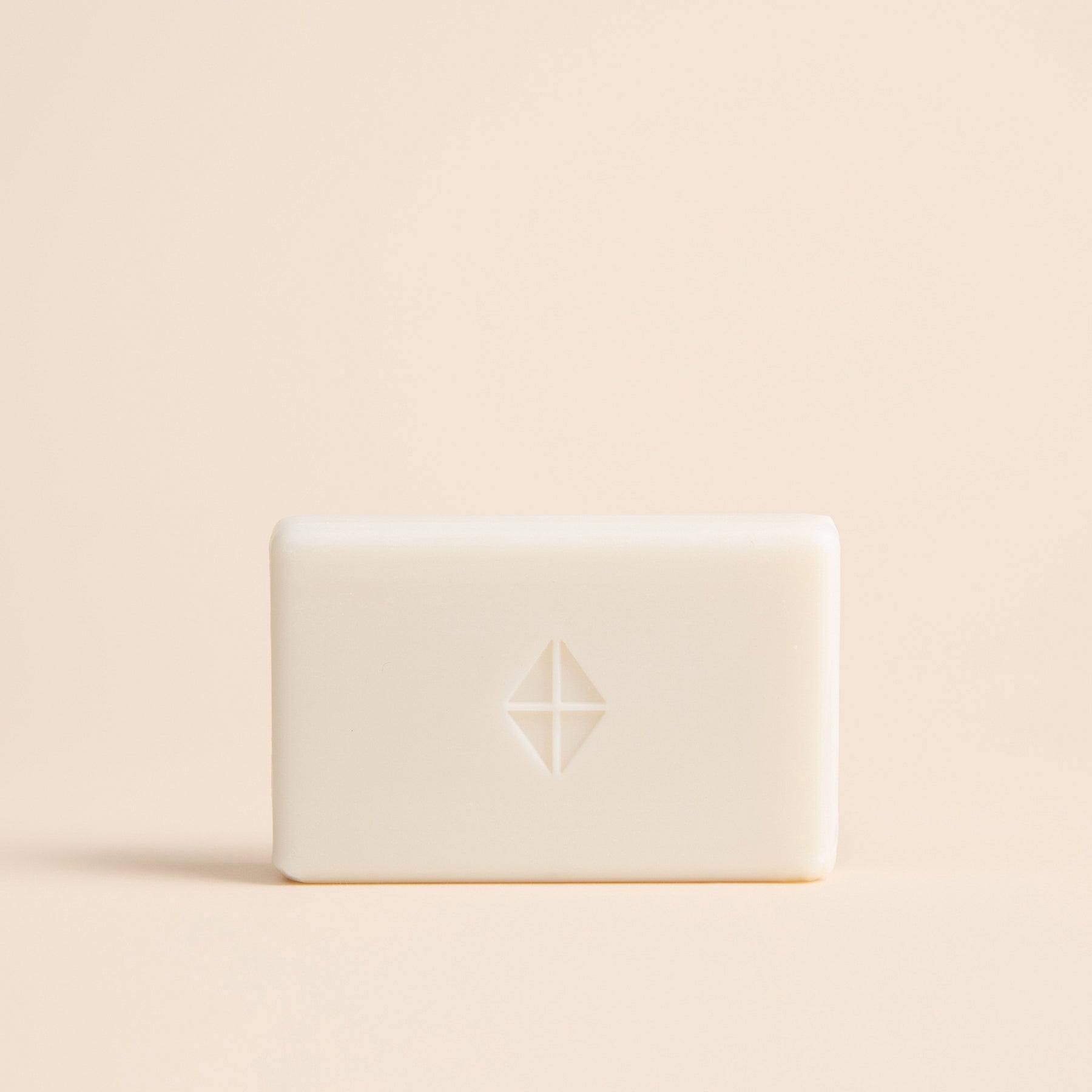 White bar of soap with a logo on a beige background