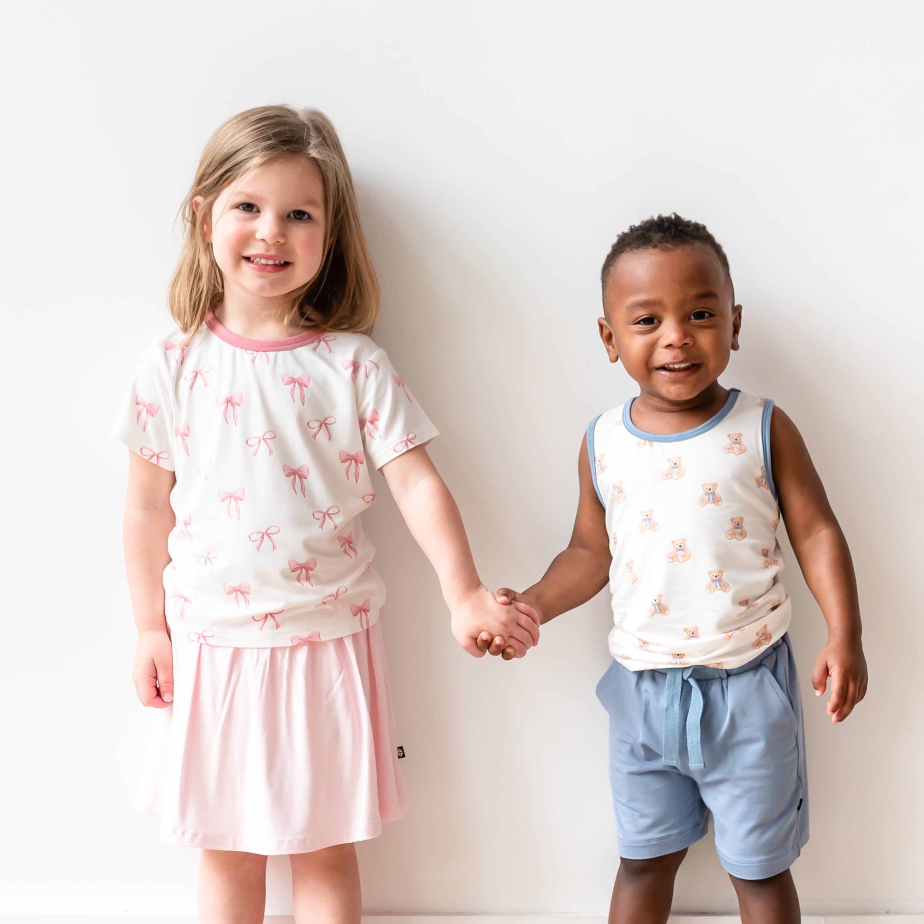 2 kids modeling Bow and Teddy Bear apparel from Kyte Baby
