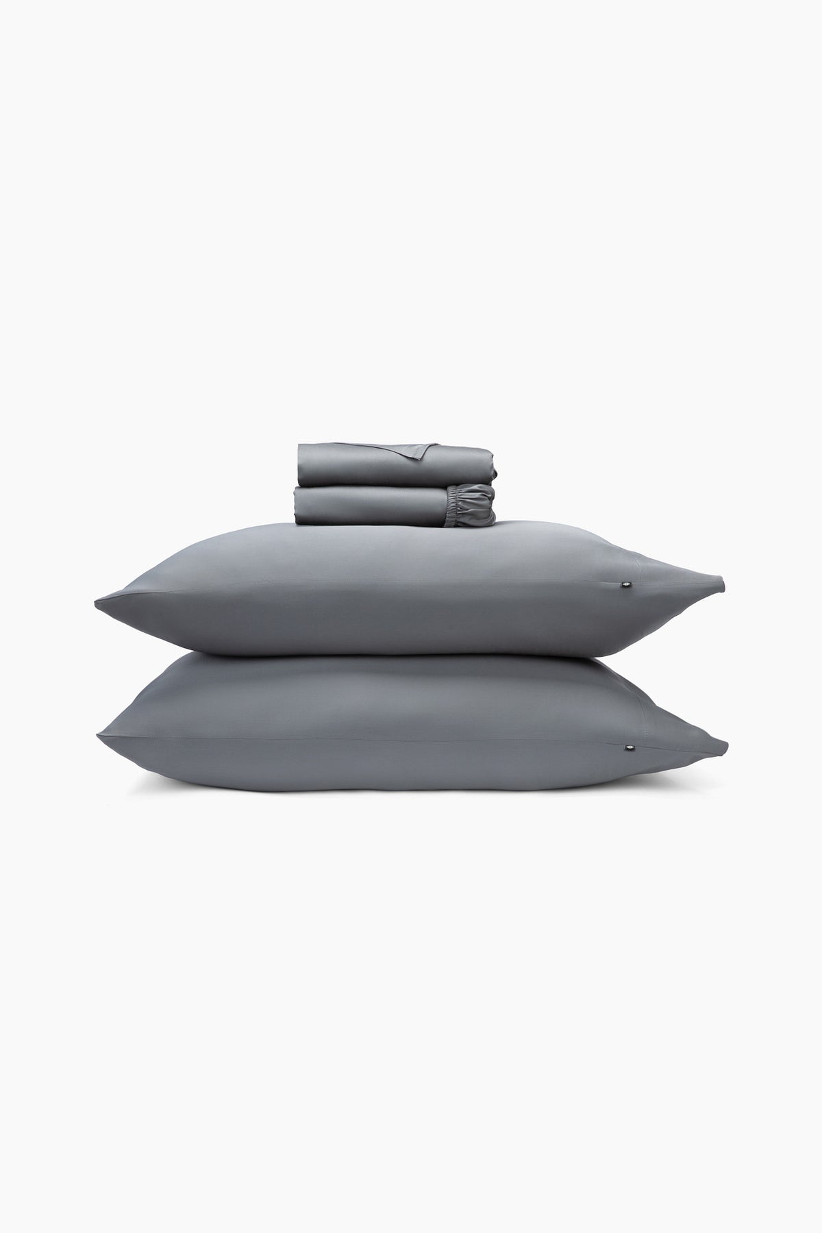 Gray bedding set with two pillows and a folded sheets on a white background