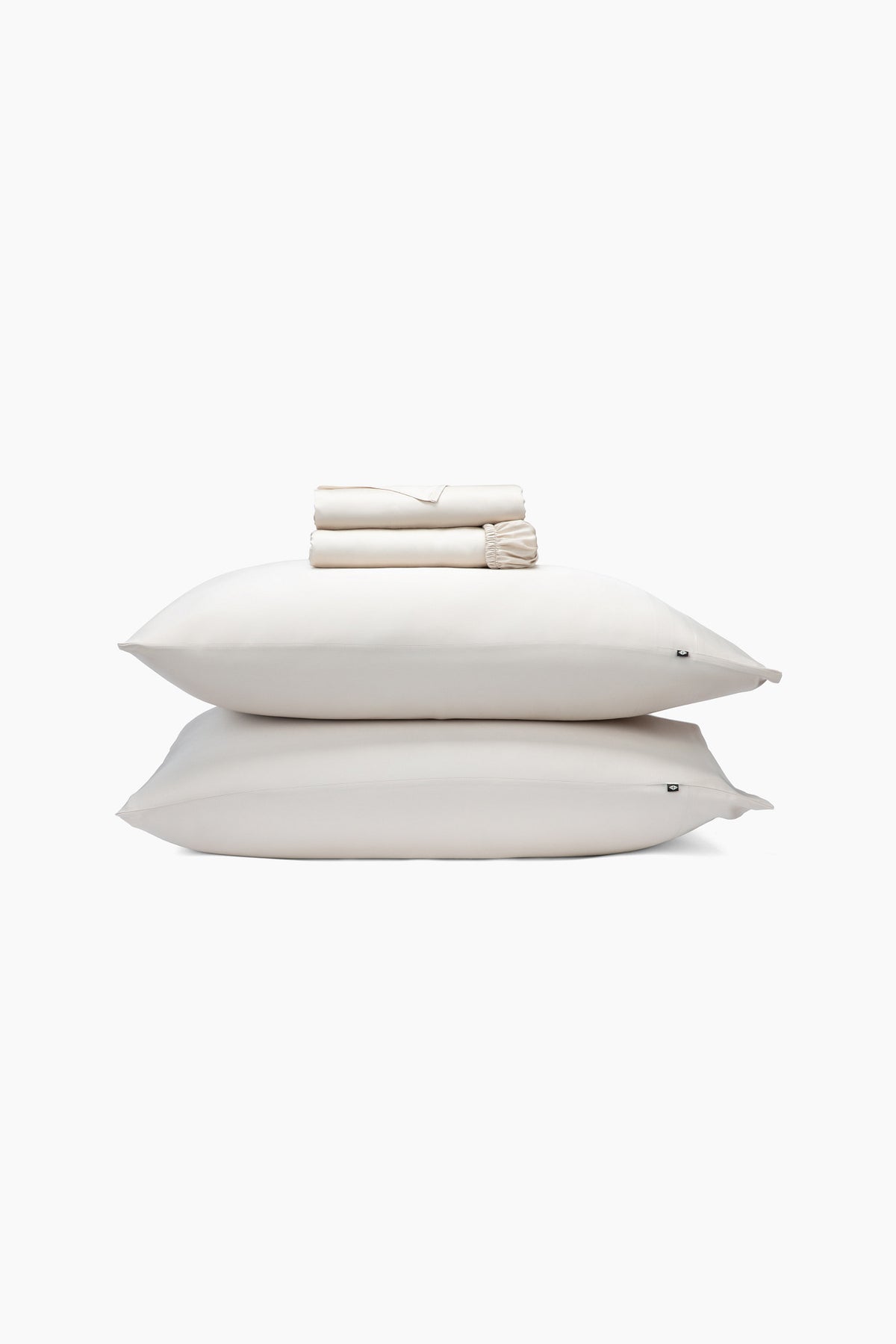 Stack of champagne pillows and folded sheets on a white background