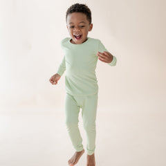 Toddler wearing light green long sleeve and pant pajama set 