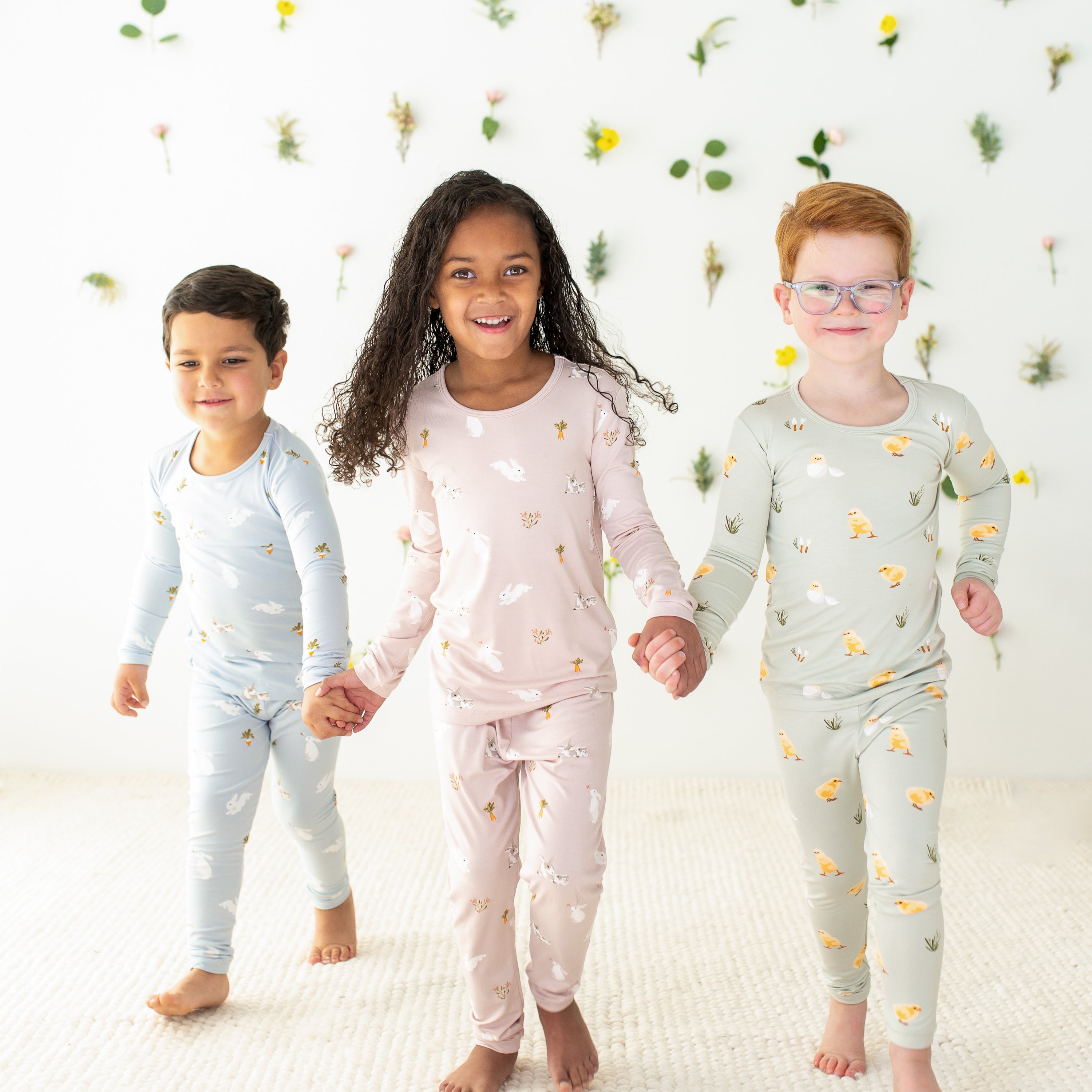 3 toddlers wearing kyte baby easter collection prints pajamas