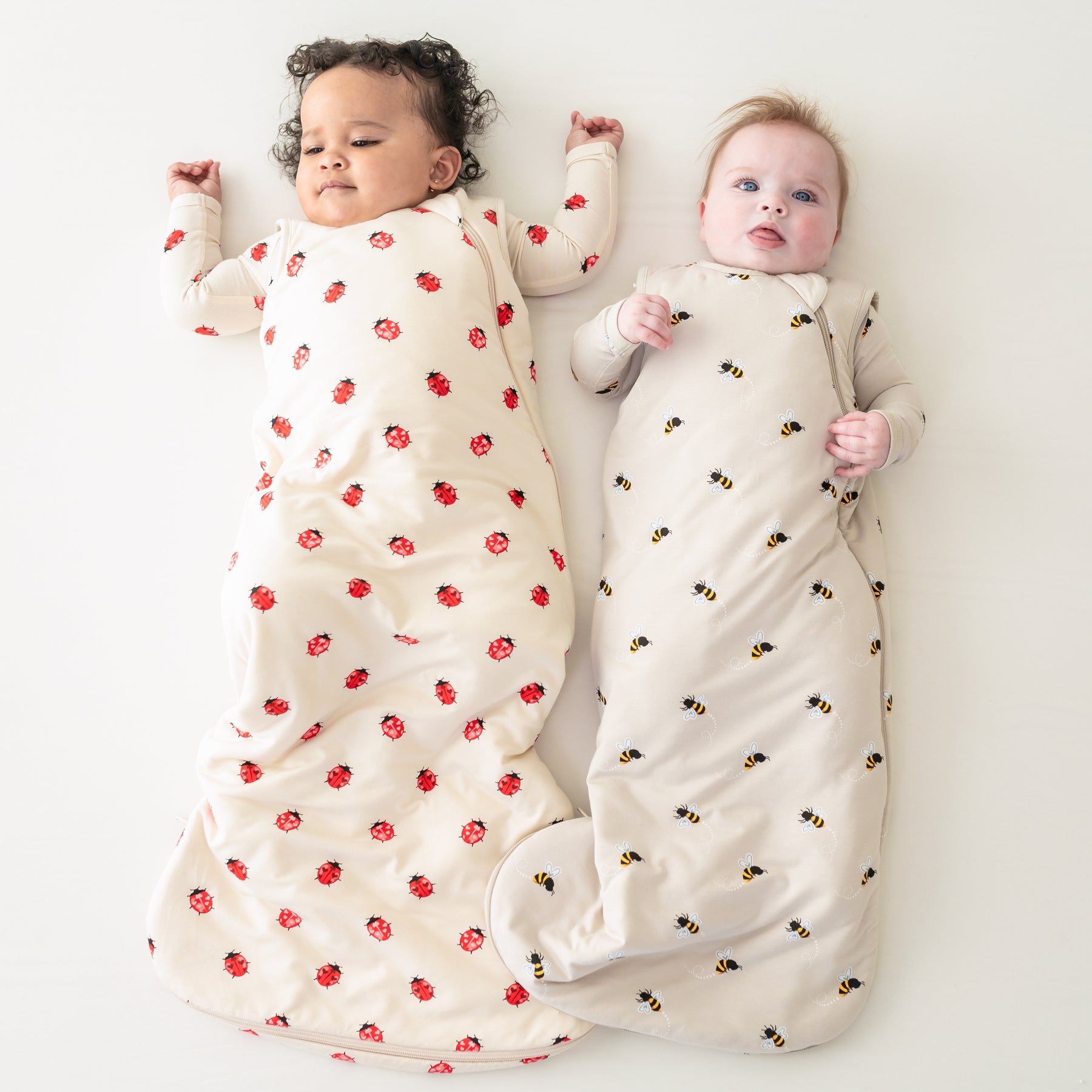 Two babies laying wearing sleep bags in Love Bug and Bee Mine