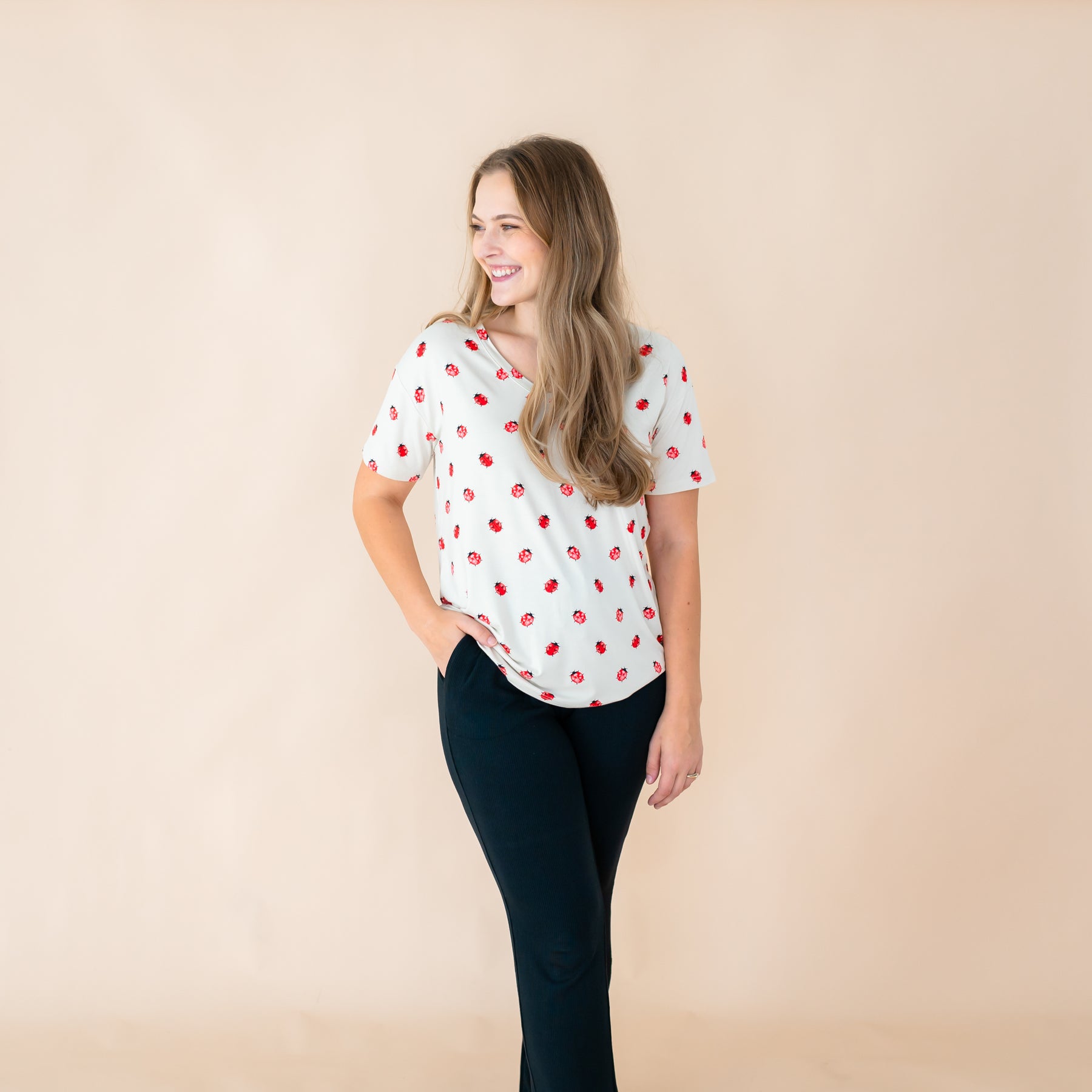 Woman modeling v-neck tee in Love Bug with hand in pocket on midnight lounge pants 