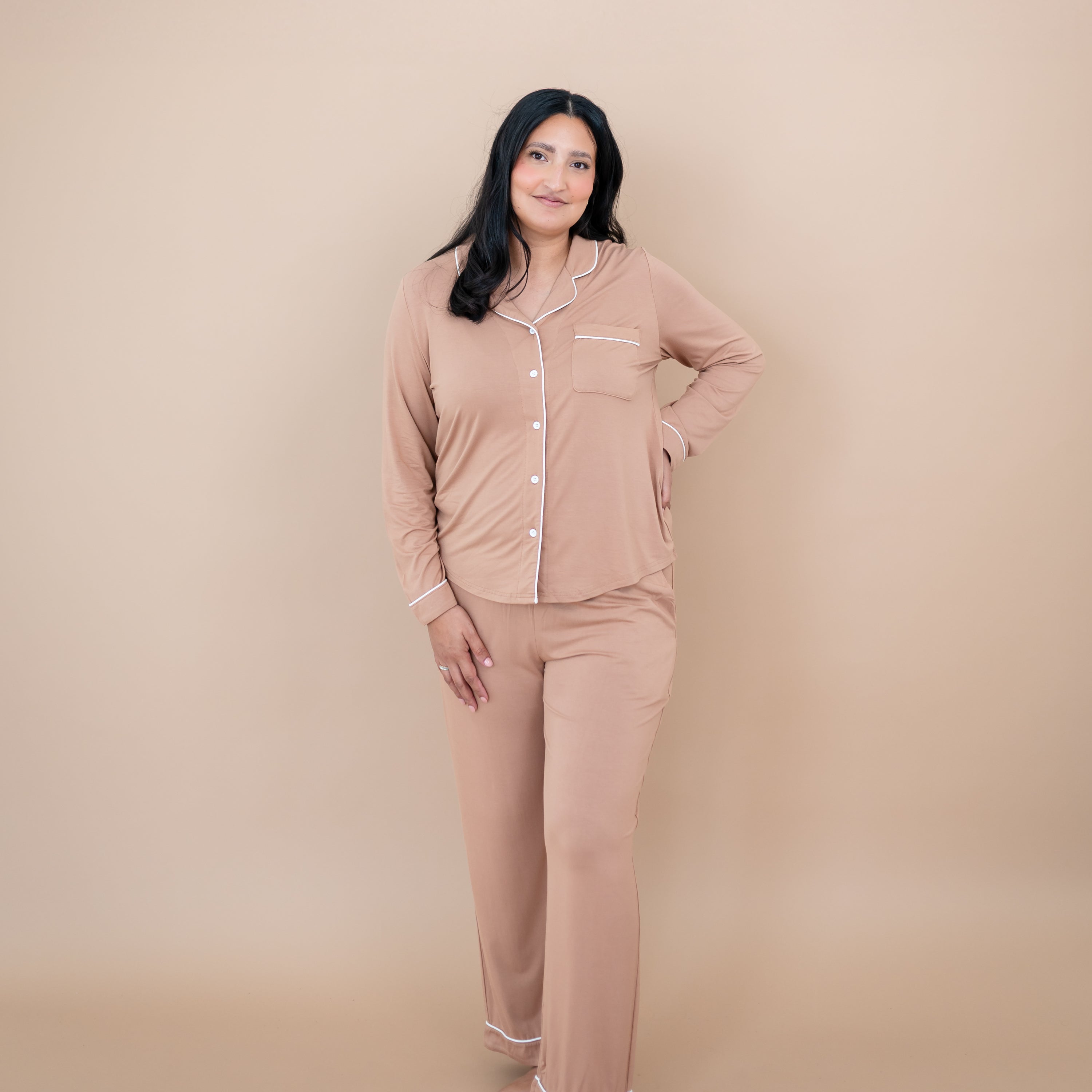 Female model standing with one hand on hip wearing the Long-Sleeved Women's Pajama Set in Latte with Cloud Trim