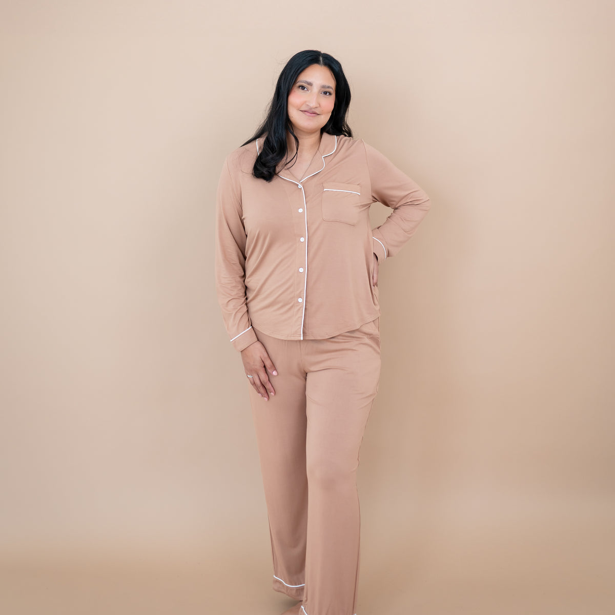 Female model standing with one hand on hip wearing the Long-Sleeved Women's Pajama Set in Latte with Cloud Trim
