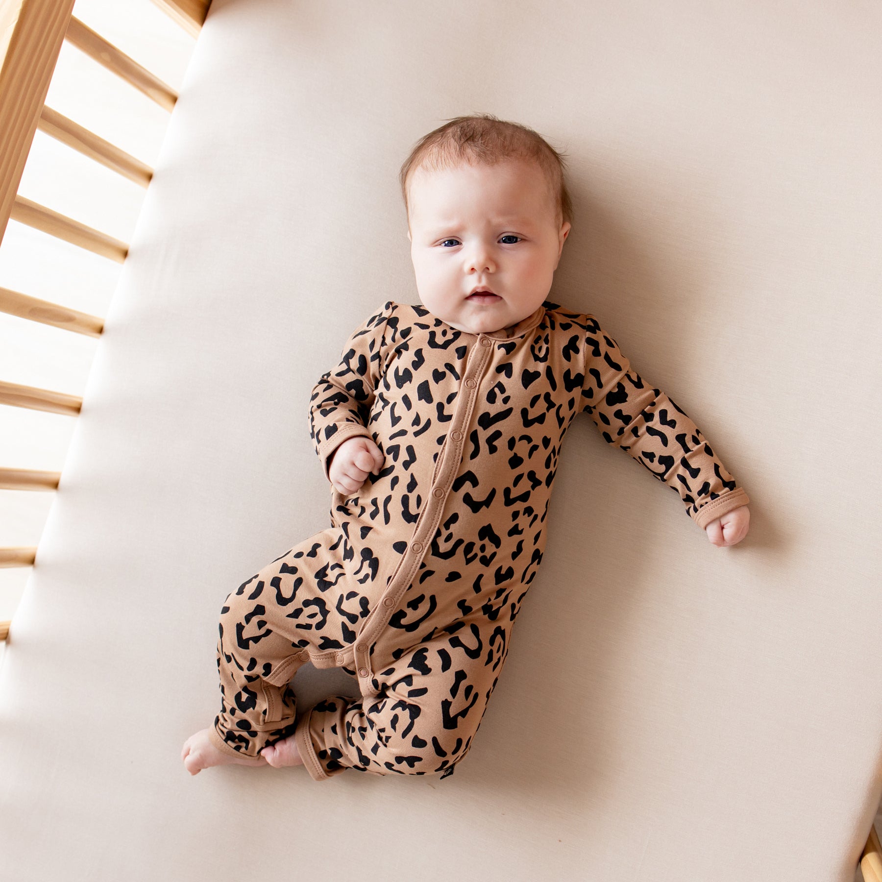 Infant wearing snap Romper in Latte Leopard