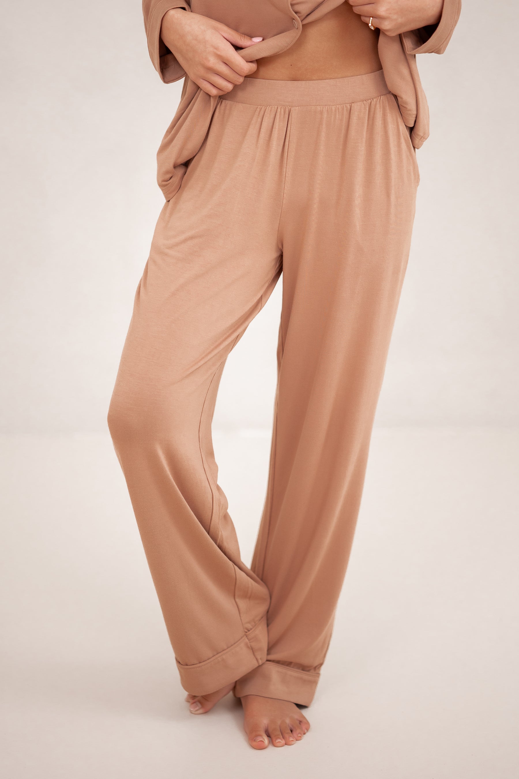 The pants of the Long-Sleeved Women's Pajama Set in Latte with Latte Trim shown on a model
