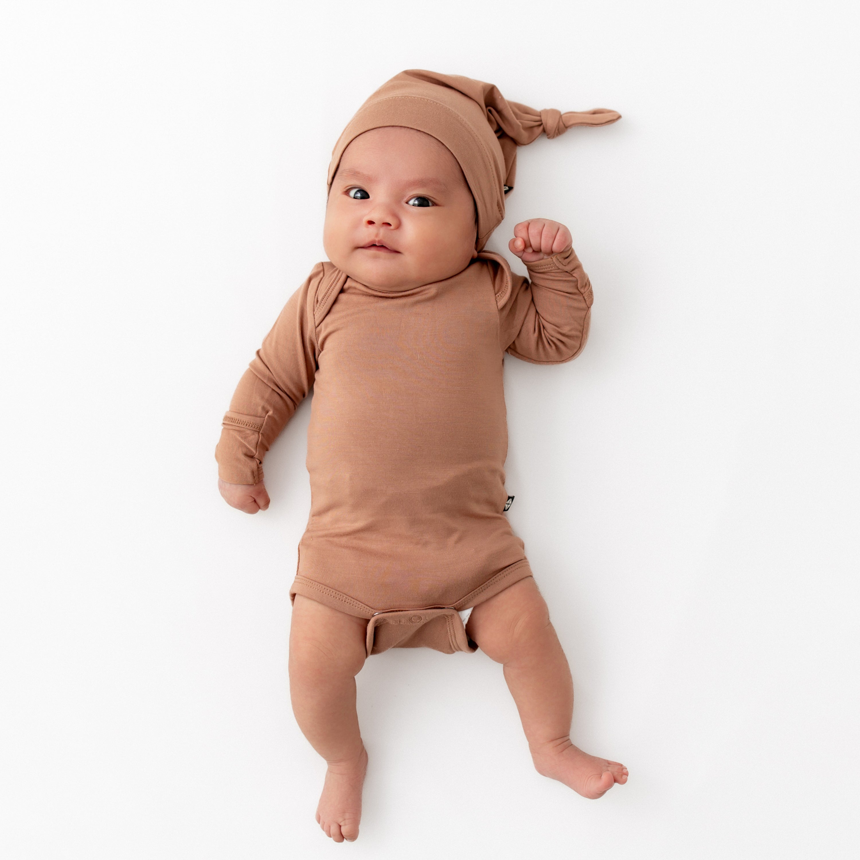 Newborn wearing the Knotted Cap in Latte paired with matching long sleeve bodysuit