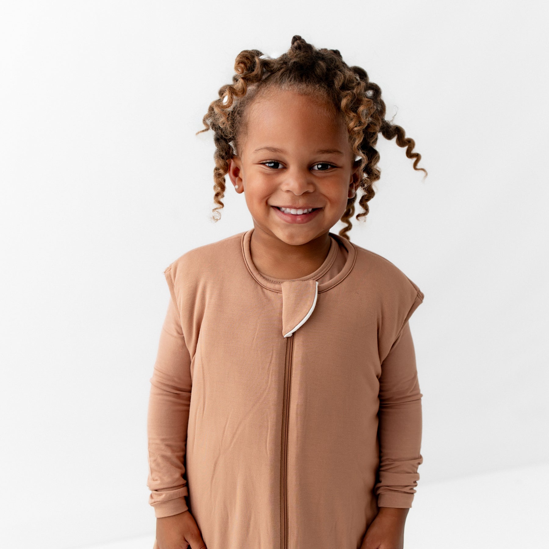 Close up of the Sleep Bag Walker in Latte 2.5's zipper garage and zipper track shown being worn on a child