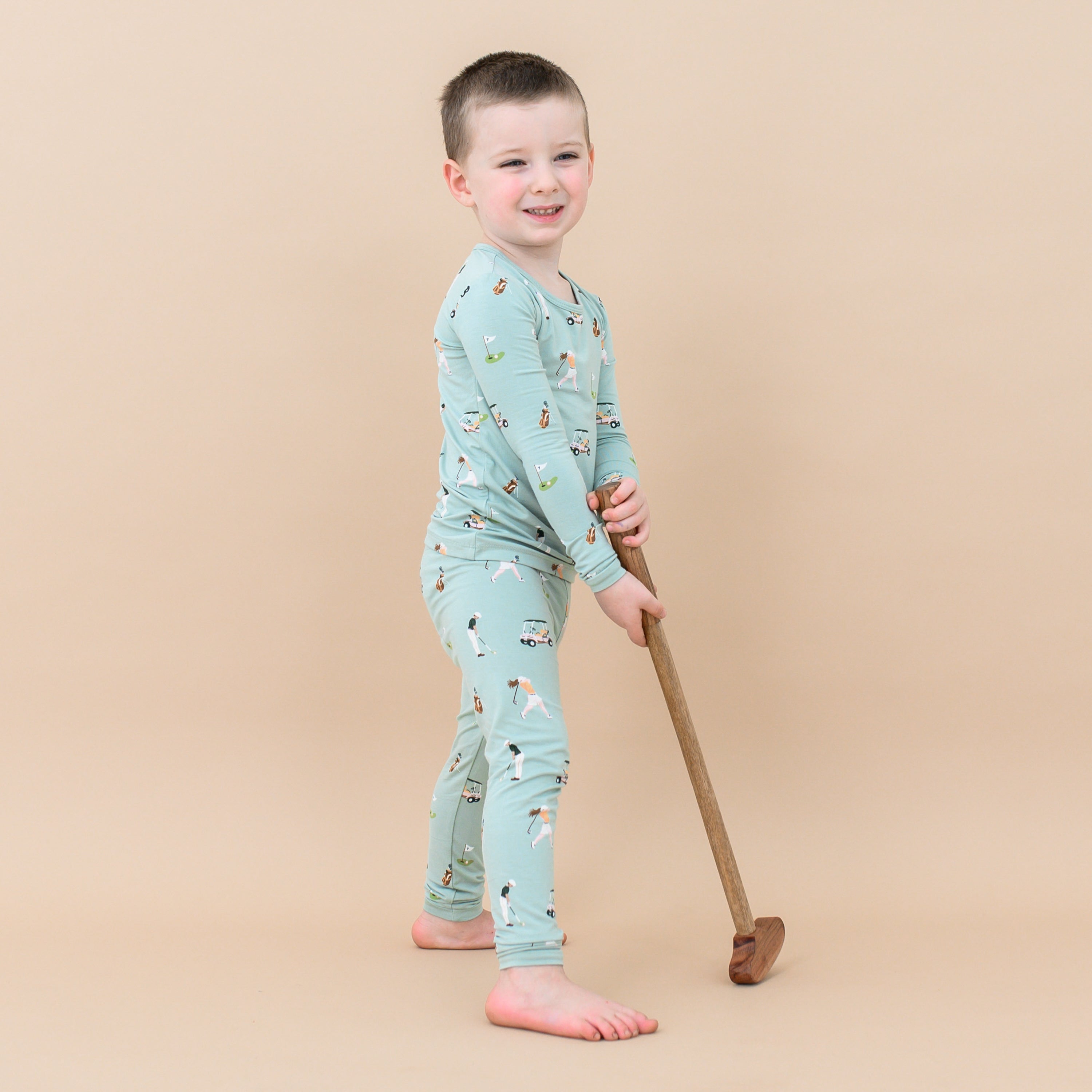 Toddler wearing Long Sleeve Pajamas in Golf with toy golf club