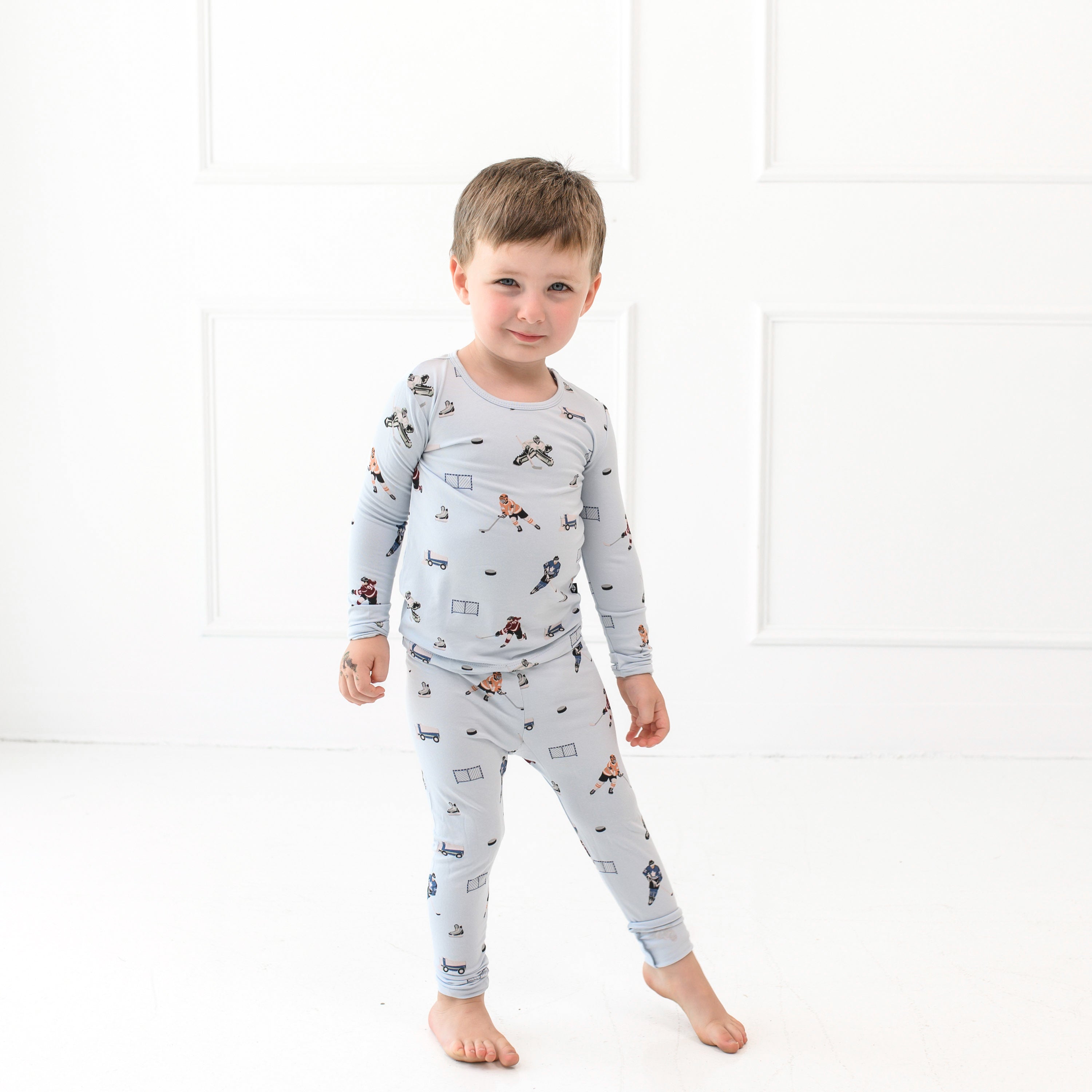 Child wearing Kyte Baby Long Sleeve Pajamas in Hockey