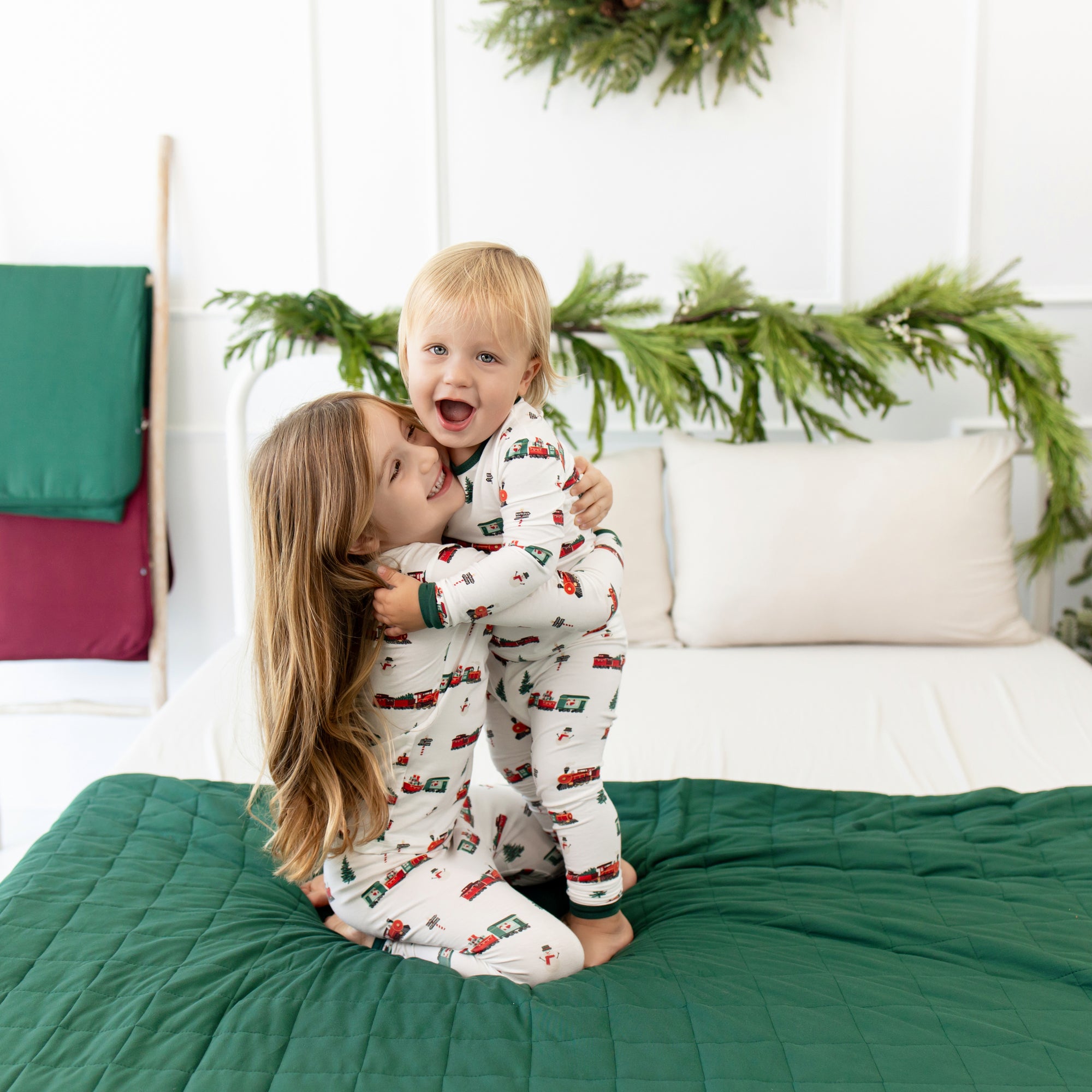 2 toddlers hugging in holiday train long sleeve pajamas