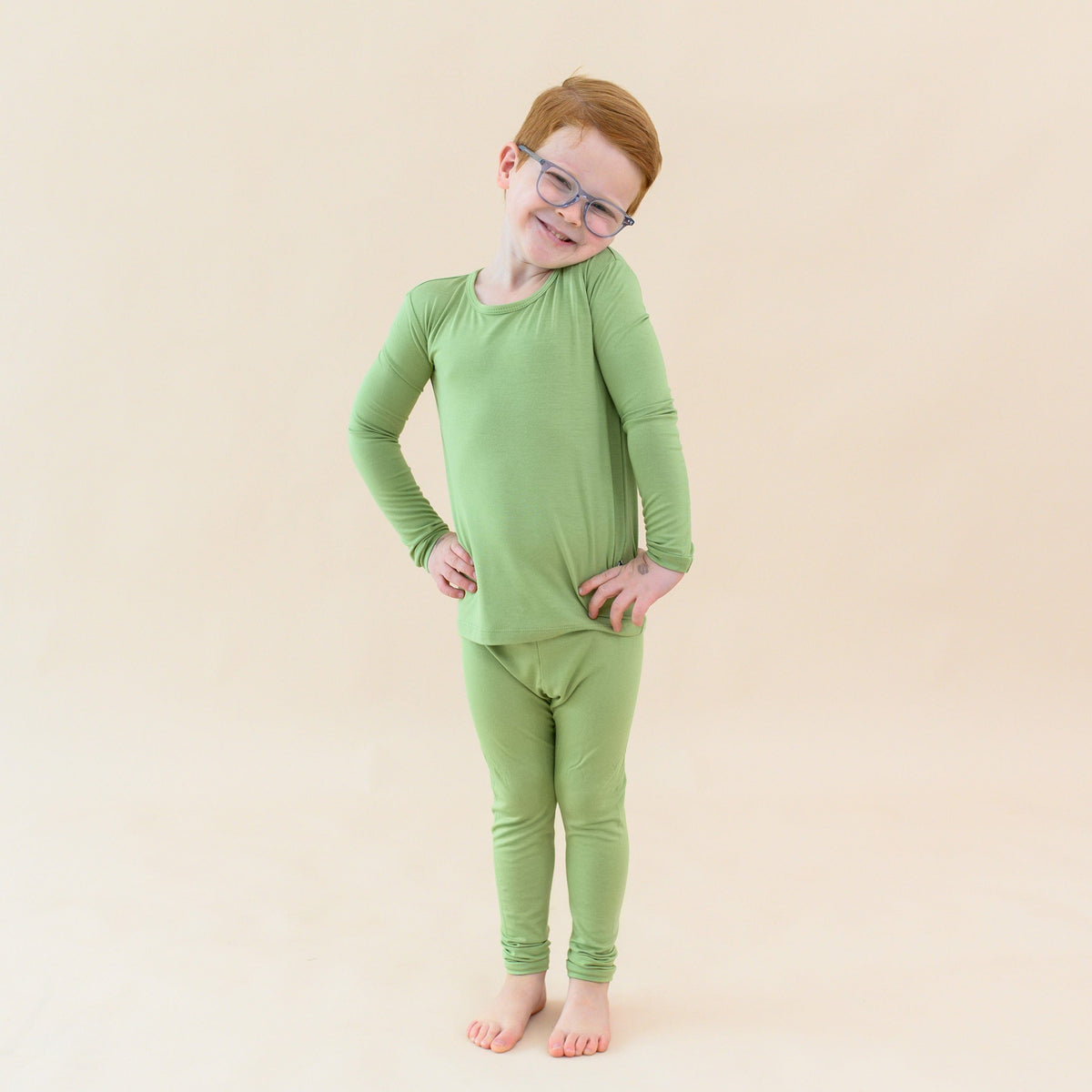 toddler modeling long sleeve pajamas in honu