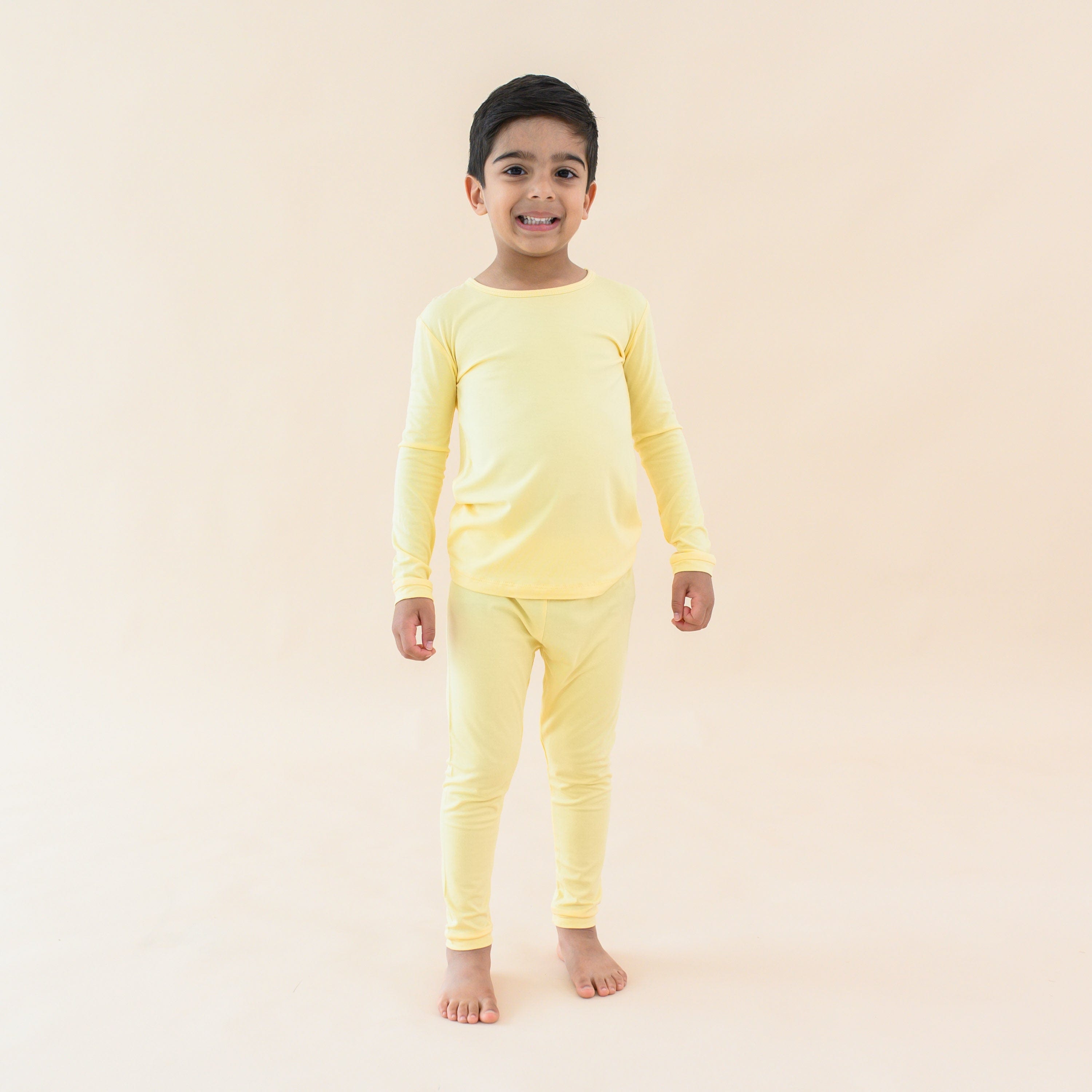 toddler wearing kyte baby long sleeve pajamas in lilikoi